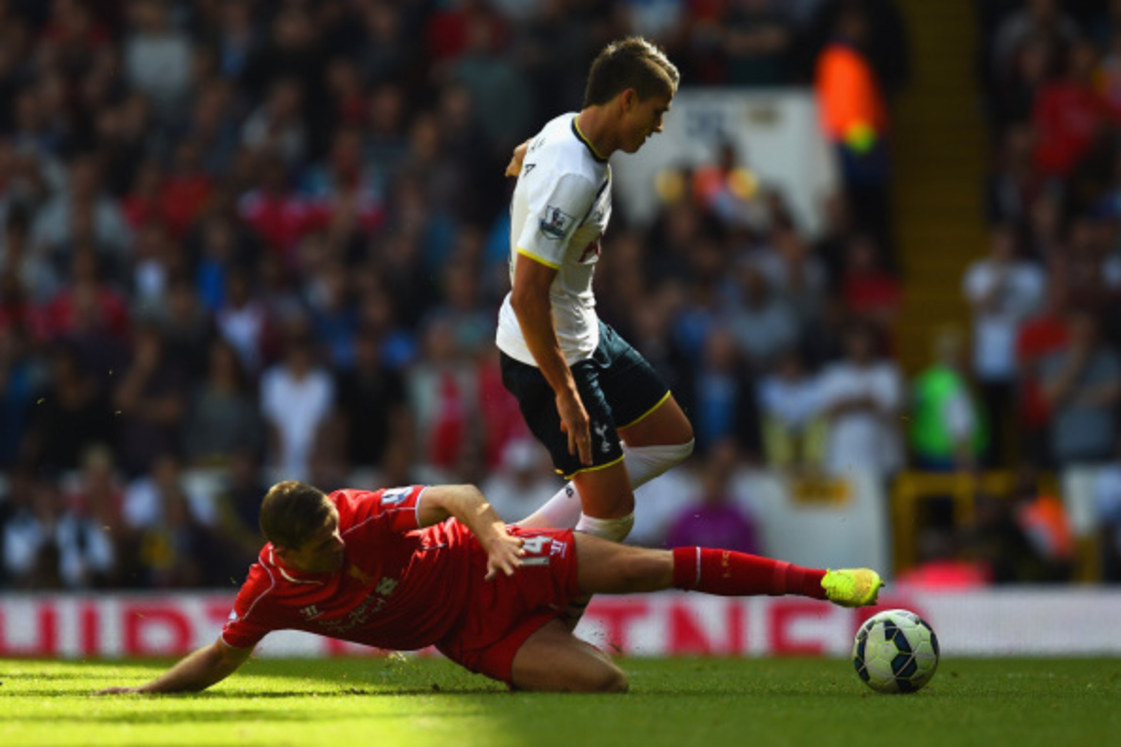 LONDON, ENGLAND - AUGUST 31:  Erik Lamela of Spurs leaps over the challenge from Jordan Henderson of Liverpool during the Barclays Premier League match between Tottenham Hotspur and Liverpool at White Hart Lane on August 31, 2014 in London, England.  (Pho