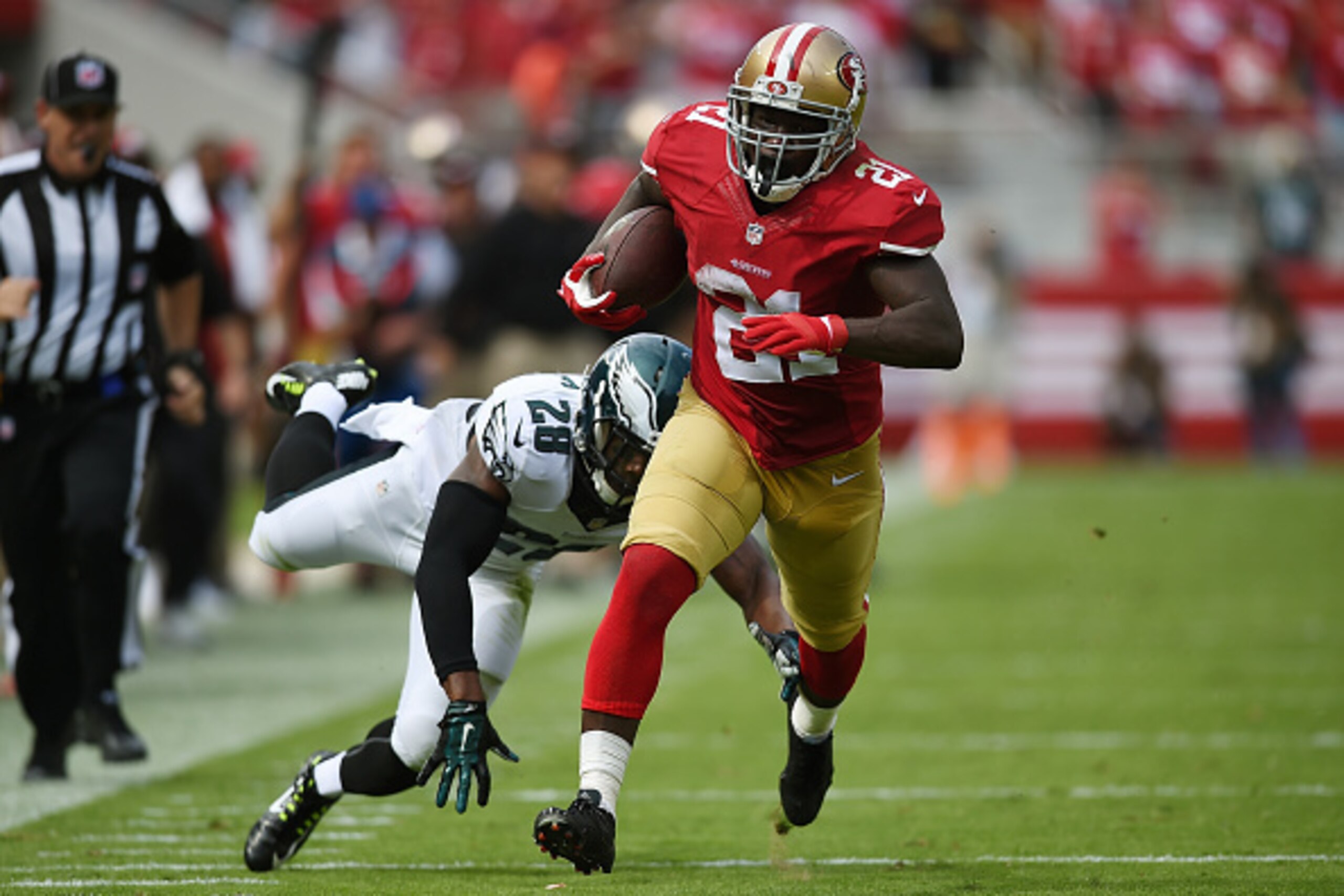 SANTA CLARA, CA - SEPTEMBER 28:  Frank Gore #21 of the San Francisco 49ers runs with the football enroute to scoring on a 55-yard pass, breaking the tackle of Earl Wolf #28 of the Philadelphia Eagles during the second quarter at Levi's Stadium on Septembe