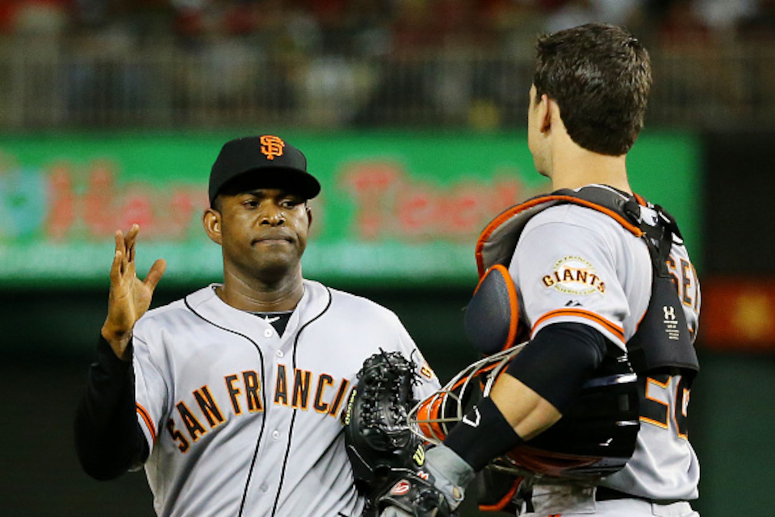 WASHINGTON, DC - OCTOBER 03:  Buster Posey #28 and Santiago Casilla #46 of the San Francisco Giants celebrate their 3 to 2 win over the Washington Nationals during Game One of the National League Division Series at Nationals Park on October 3, 2014 in Was