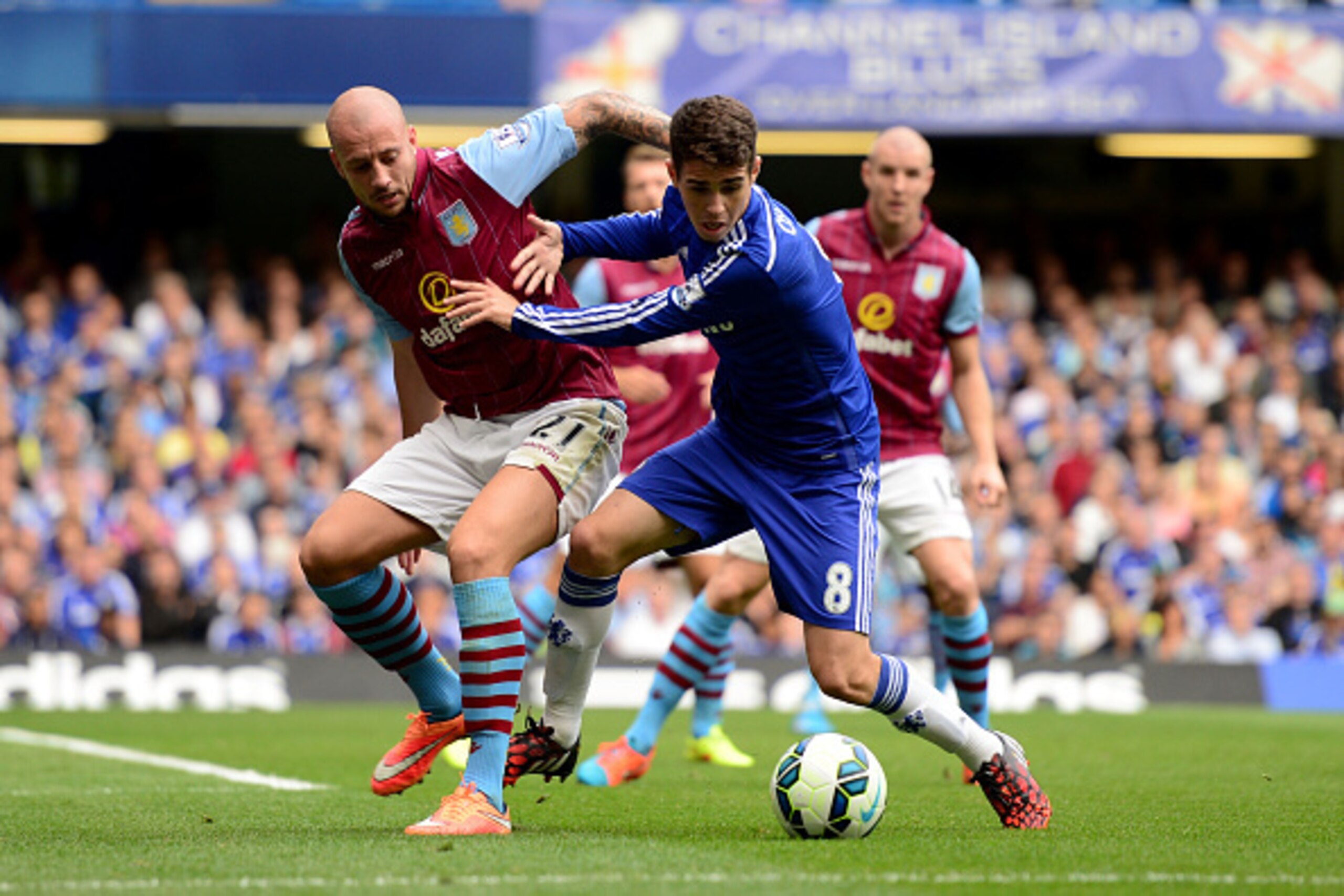 LONDON, ENGLAND - SEPTEMBER 27:  Oscar of Chelsea holds off the challenge from Alan Hutton of Aston Villa during the Barclays Premier League match between Chelsea and Aston Villa at Stamford Bridge on September 27, 2014 in London, England.  (Photo by Jami
