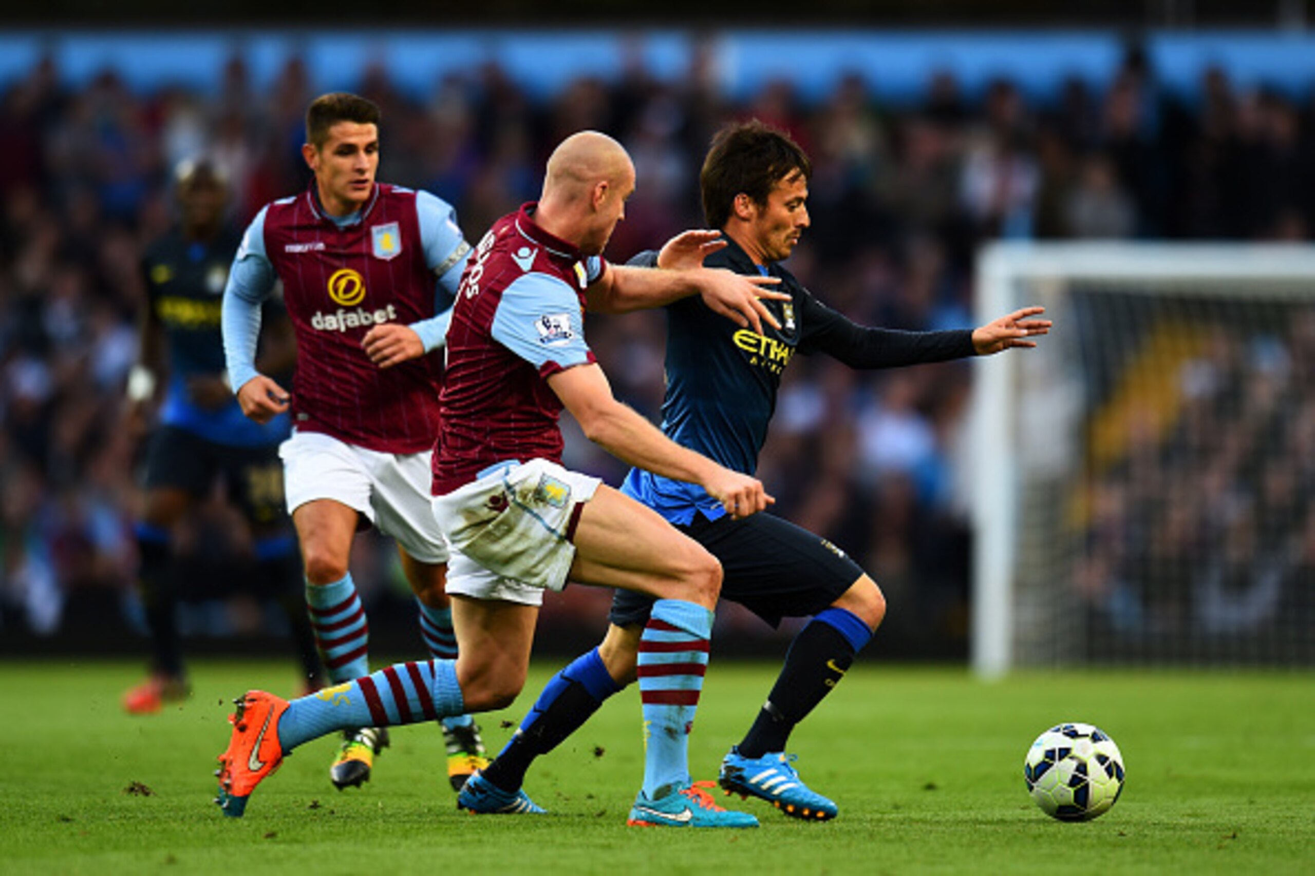BIRMINGHAM, ENGLAND - OCTOBER 04:  David Silva of Manchester City runs with the ball past Philippe Senderos of Aston Villa during the Barclays Premier League match between Aston Villa and Manchester City at Villa Park on October 4, 2014 in Birmingham, Eng
