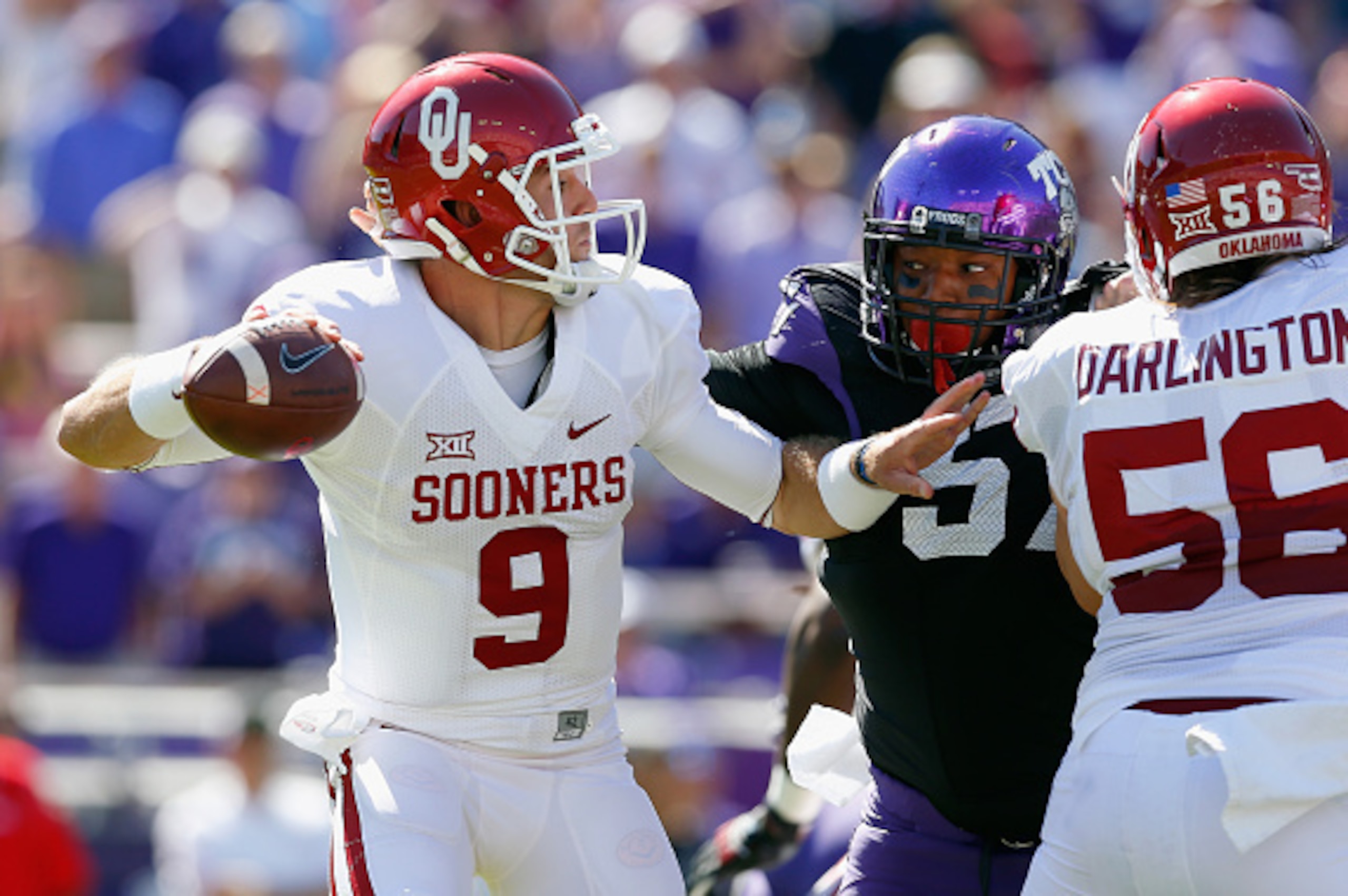 FORT WORTH, TX - OCTOBER 04: Quarterback Trevor Knight #9 of the Oklahoma Sooners looks for an ope receiver under pressure from defensive tackle Davion Pierson #57 of the TCU Horned Frogs and defensive end Josh Carraway #94 of the TCU Horned Frogs in the FORT WORTH, TX - OCTOBER 04: Quarterback Trevor Knight #9 of the Oklahoma Sooners looks for an ope receiver under pressure from defensive tackle Davion Pierson #57 of the TCU Horned Frogs and defensive end Josh Carraway #94 of the TCU Horned Frogs in the