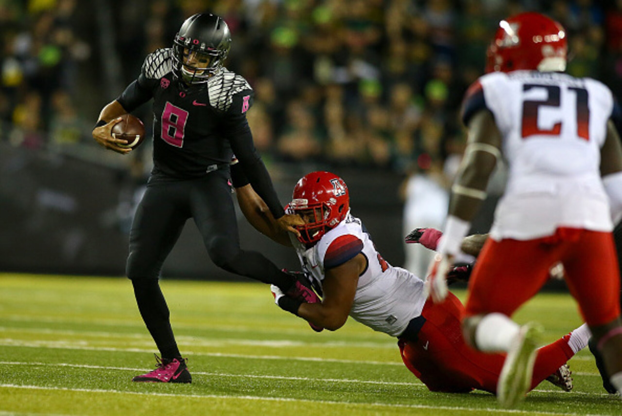 EUGENE, OR - OCTOBER 02:  Quarterback Marcus Mariota #8 of the Oregon Ducks fights off Abraham Mendivil #84 of the Arizona Wildcats at Autzen Stadium on October 2, 2014  in Eugene, Oregon.  (Photo by Jonathan Ferrey/Getty Images)