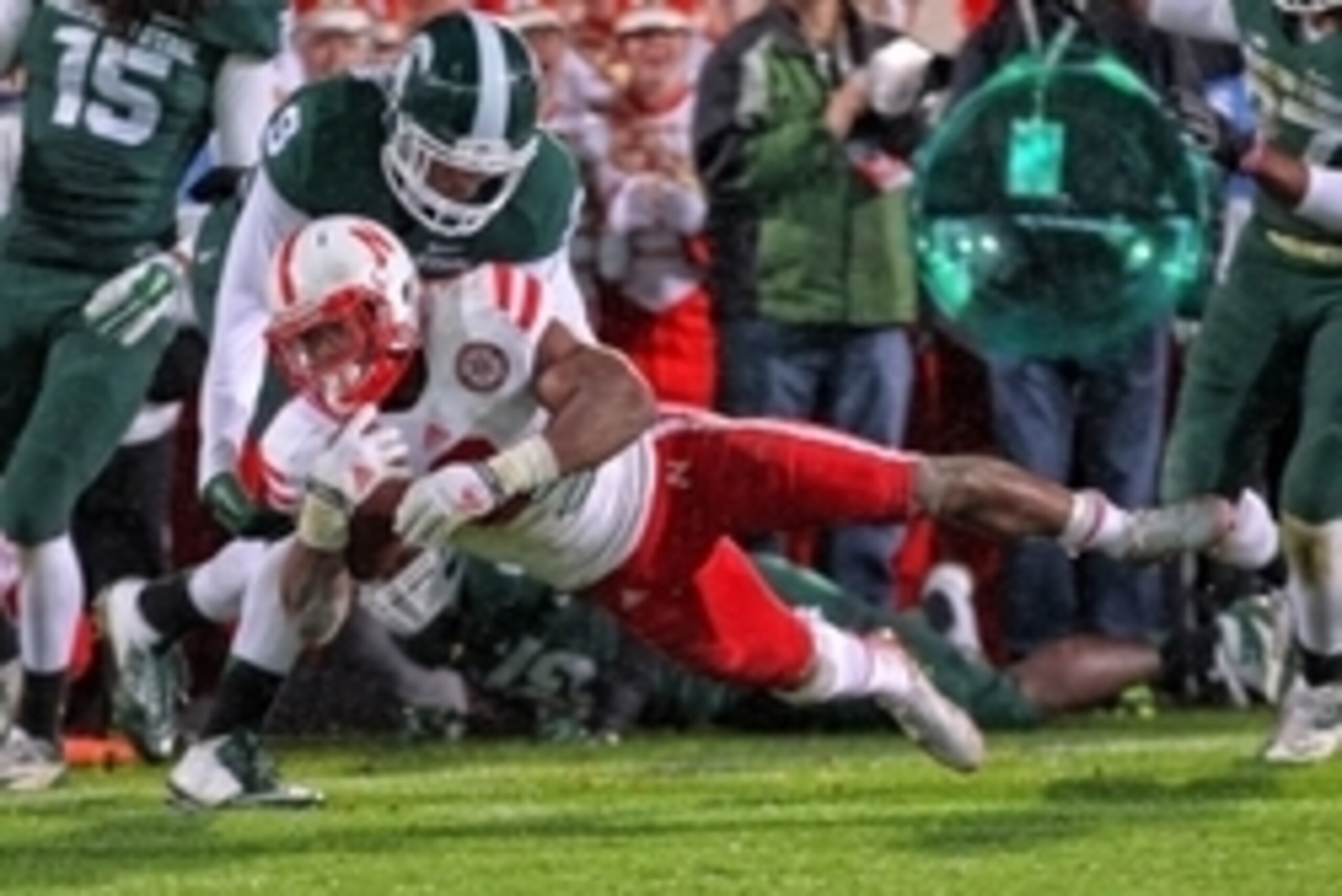 Oct 4, 2014; East Lansing, MI, USA; Nebraska Cornhuskers running back Ameer Abdullah (8) stretches for extra yards against Michigan State Spartans defensive back Montae Nicholson (9)  during the 1st half of a game at Spartan Stadium. Mandatory Credit: Mik