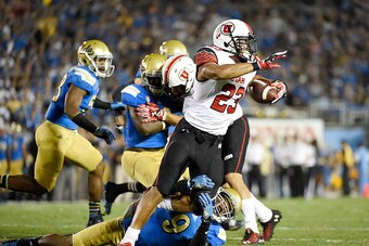 PASADENA, CA - OCTOBER 04: Devontae Booker #23 running back of the Utah Utes is tackled for loss of yardage by Marcus Rios #9 of the UCLA Bruins during the first half at the Rose Bowl October 04, 2014, in Pasadena, California. (Photo by Kevork Djansezian/