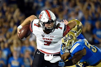 PASADENA, CA - OCTOBER 04: Quarterback Travis Wilson #7 of the Utah Utes scrambles out of the pocket as he is chased down by UCLA Bruins defenders during the first quarter at the Rose Bowl October 04, 2014, in Pasadena, California. (Photo by Kevork Djanse