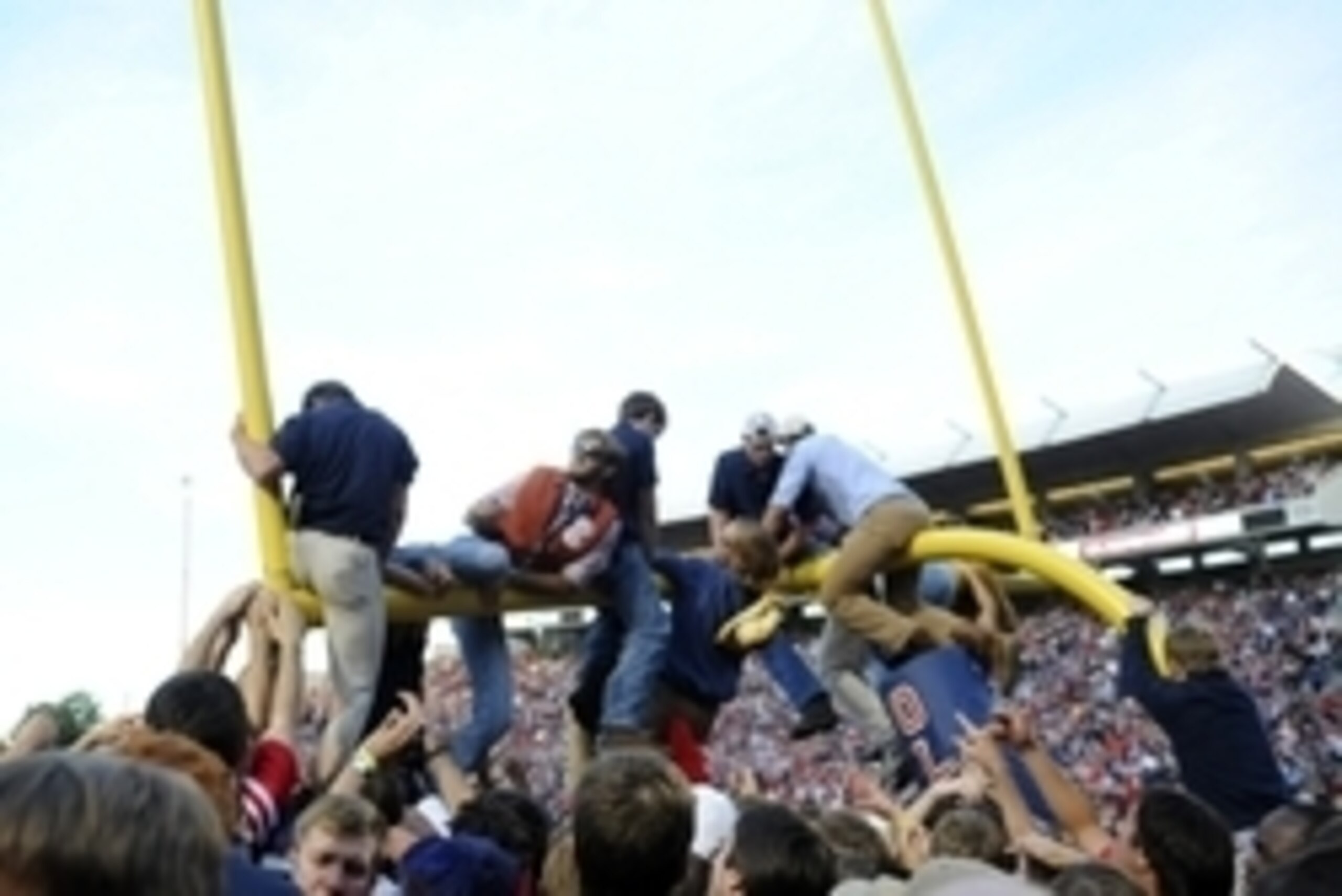Oct 4, 2014; Oxford, MS, USA; Mississippi Rebels fans hang from the goal posts after a win against the Alabama Crimson Tide at Vaught-Hemingway Stadium. The Rebels won 23-17. Mandatory Credit: Christopher Hanewinckel-USA TODAY Sports