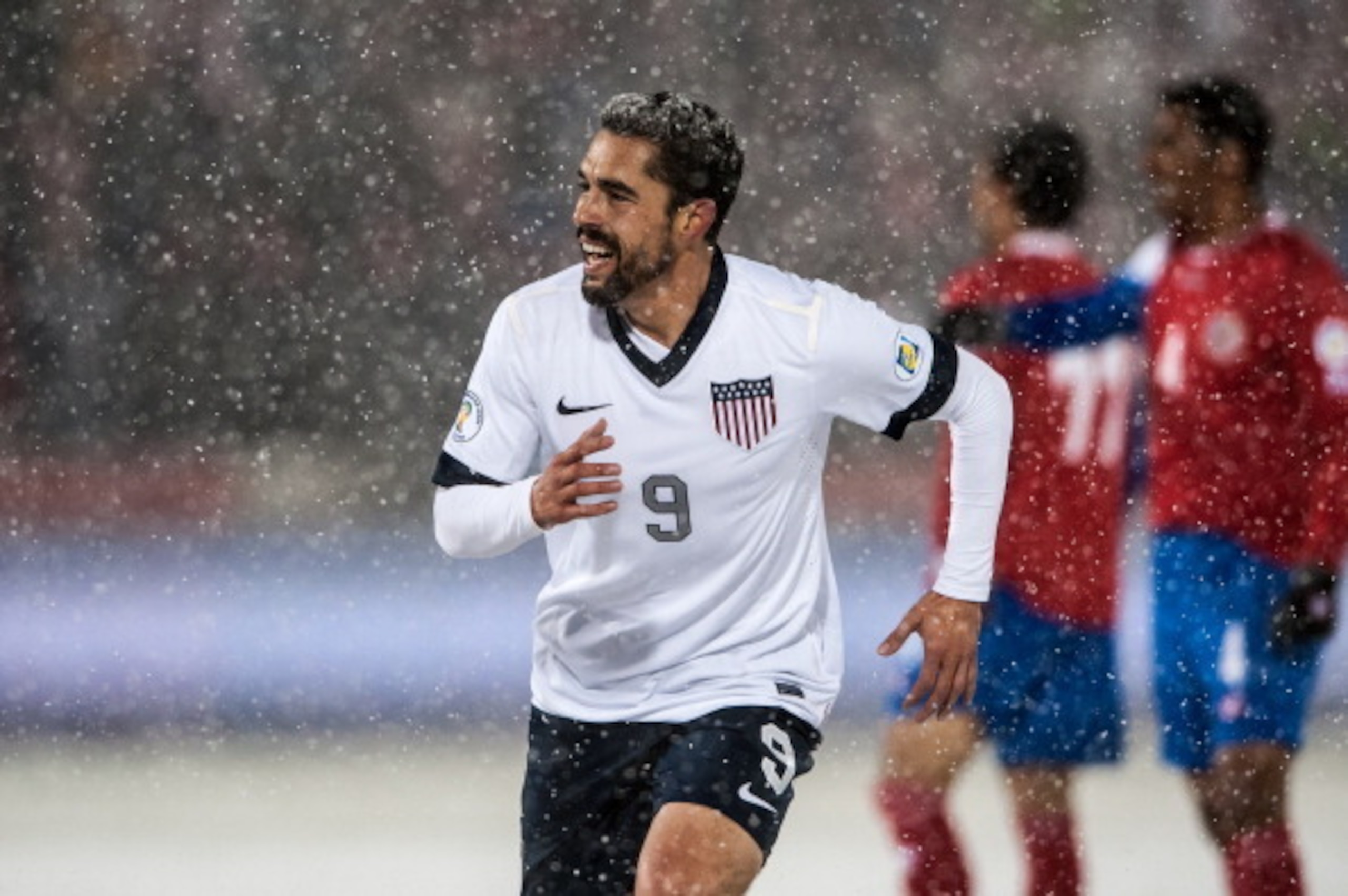 COMMERCE CITY, CO - MARCH 22: Forward Herculez Gomez #9 of the United States smiles after his teammate scored the loan goal in the game during a FIFA 2014 World Cup Qualifier match between Costa Rica and United States at Dick's Sporting Goods Park on Mar COMMERCE CITY, CO - MARCH 22: Forward Herculez Gomez #9 of the United States smiles after his teammate scored the loan goal in the game during a FIFA 2014 World Cup Qualifier match between Costa Rica and United States at Dick's Sporting Goods Park on Mar
