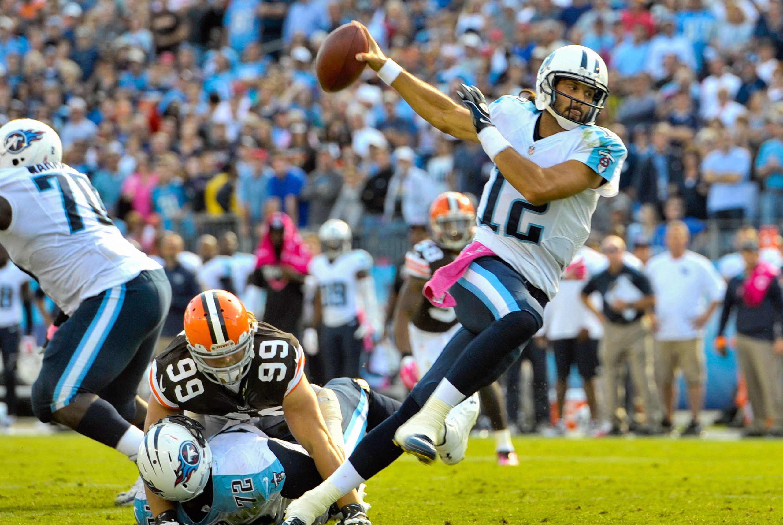 Oct 5, 2014; Nashville, TN, USA; Tennessee Titans quarterback Charlie Whitehurst (12) scrambles to avoid the sack from Cleveland Browns outside linebacker Paul Kruger (99) during the second half at LP Field. Cleveland won 29-28. Mandatory Credit: Jim Brow