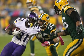 GREEN BAY, WI - OCTOBER 02:  Jerick McKinnon #31 of the Minnesota Vikings carries the football against  Micah Hyde #33 of the Green Bay Packers in the second half at Lambeau Field on October 2, 2014 in Green Bay, Wisconsin. Packers defeat Vikings 42-10. (