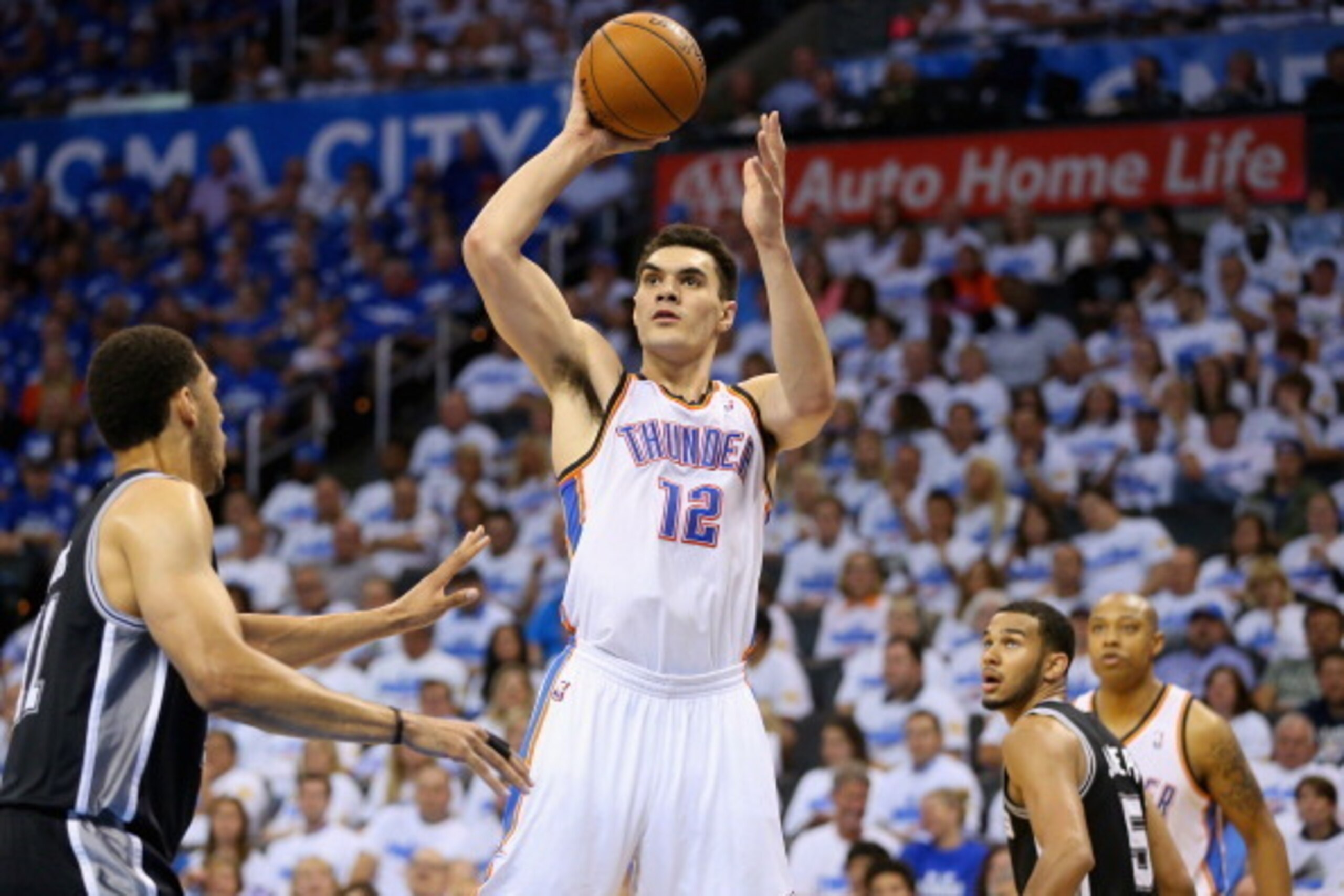 OKLAHOMA CITY, OK - MAY 27: Steven Adams #12 of the Oklahoma City Thunder looks to shoot against Jeff Ayres #11 of the San Antonio Spurs in the second half during Game Four of the Western Conference Finals of the 2014 NBA Playoffs at Chesapeake Energy Are