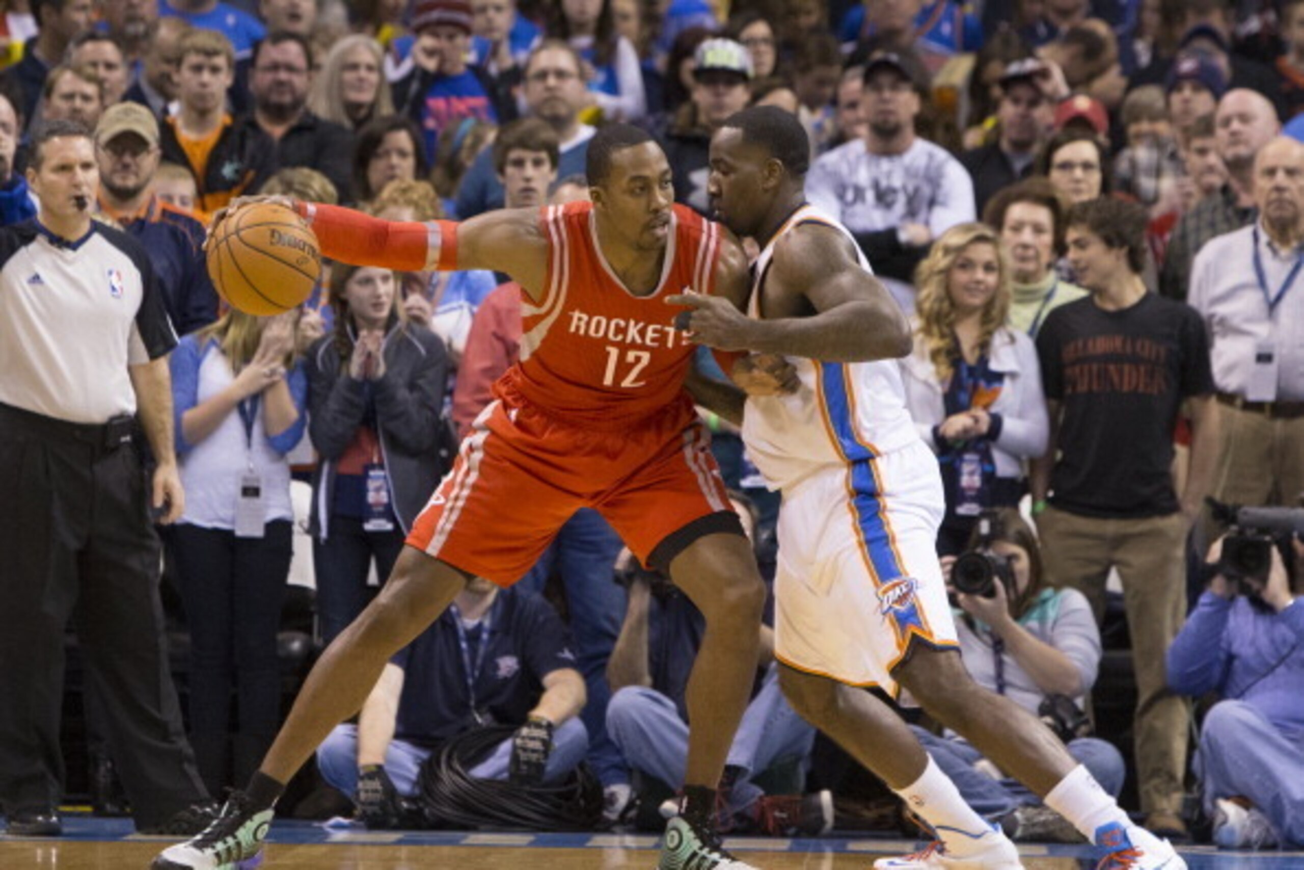 OKLAHOMA CITY, OK - DECEMBER 29 :  Dwight Howard #12 of the Houston Rockets handles the ball against Kendrick Perkins #5 of the Oklahoma City Thunder at the Chesapeake Arena on December 29, 2013 in Oklahoma City, Oklahoma. NOTE TO USER:  User expressly ac