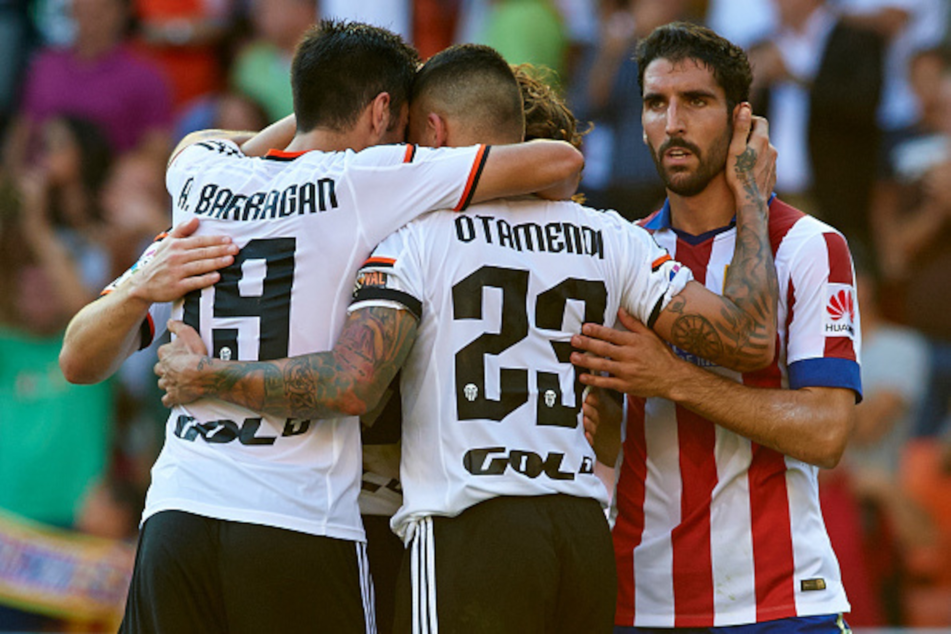 VALENCIA, SPAIN - OCTOBER 04:  Players of Valencia celebrate behind Raul Garcia of Atletico de Madrid after the La Liga match between Valencia CF and Club Atletico de Madrid at Estadi de Mestalla on October 4, 2014 in Valencia, Spain.  (Photo by Manuel Qu