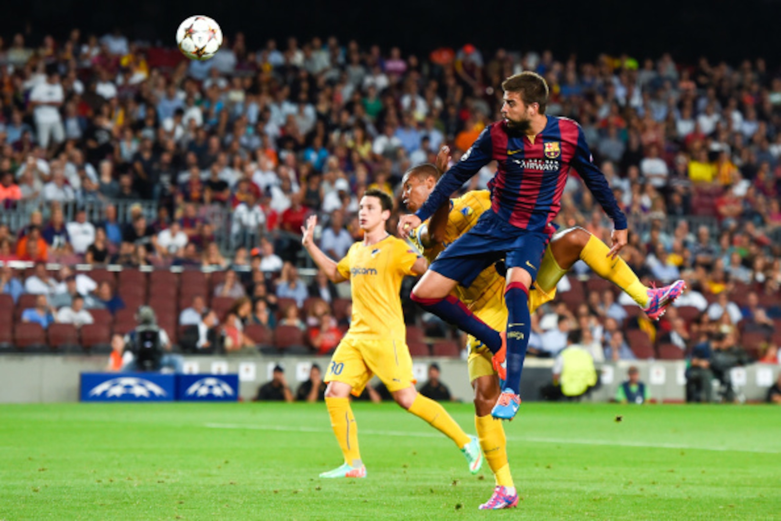 BARCELONA, SPAIN - SEPTEMBER 17: Gerard Pique of FC Barcelona heads the ball towards goal under a challenge by Joao Guilherme of APOEL FC during the UEFA Champions League Group F match between FC Barcelona and APOEL FC at the Camp Nou Stadium on Septembe BARCELONA, SPAIN - SEPTEMBER 17: Gerard Pique of FC Barcelona heads the ball towards goal under a challenge by Joao Guilherme of APOEL FC during the UEFA Champions League Group F match between FC Barcelona and APOEL FC at the Camp Nou Stadium on Septembe