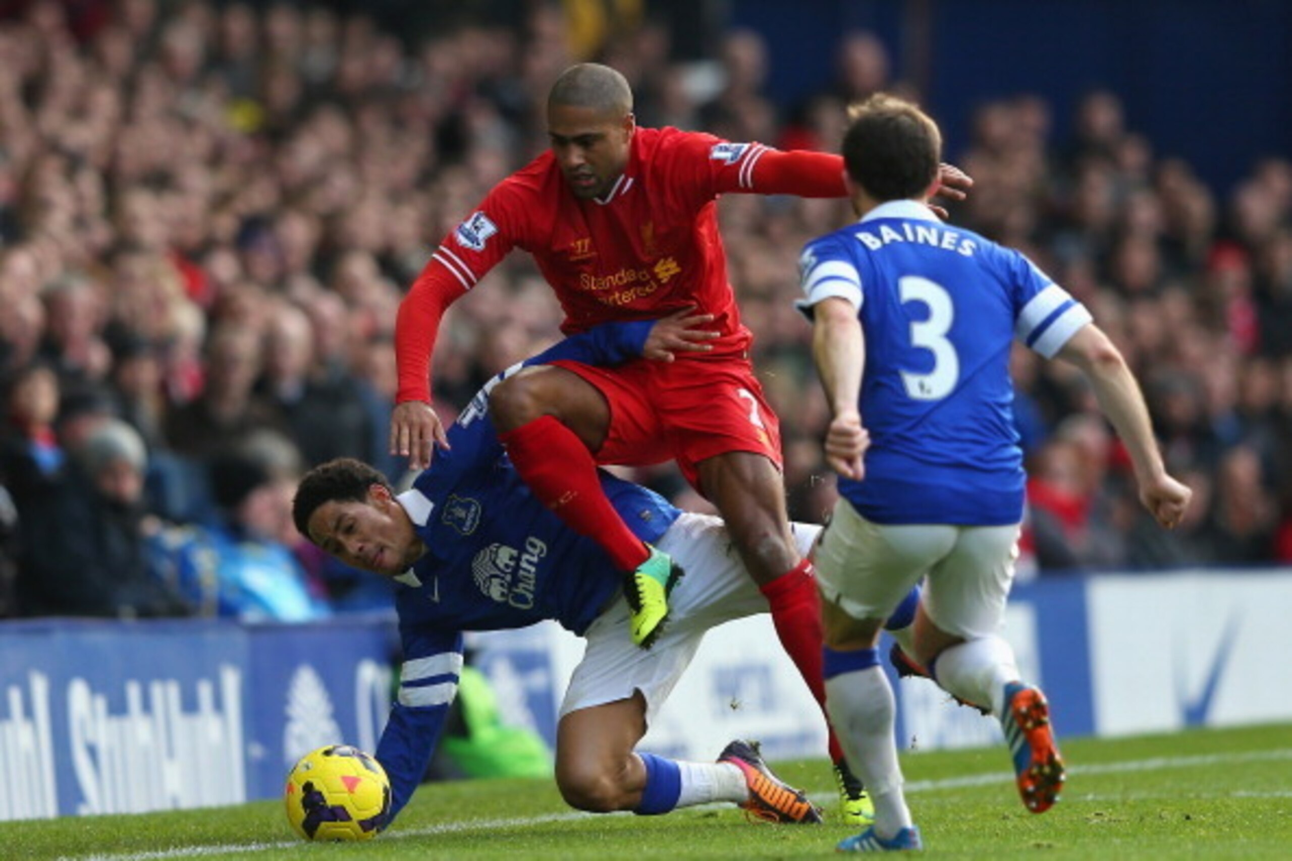 LIVERPOOL, ENGLAND - NOVEMBER 23:  Glen Johnson of Liverpool  hurdles the challenge of Steven Pienaar of Everton during the Barclays Premier League match between Everton and Liverpool at Goodison Park on November 23, 2013 in Liverpool, England.  (Photo by