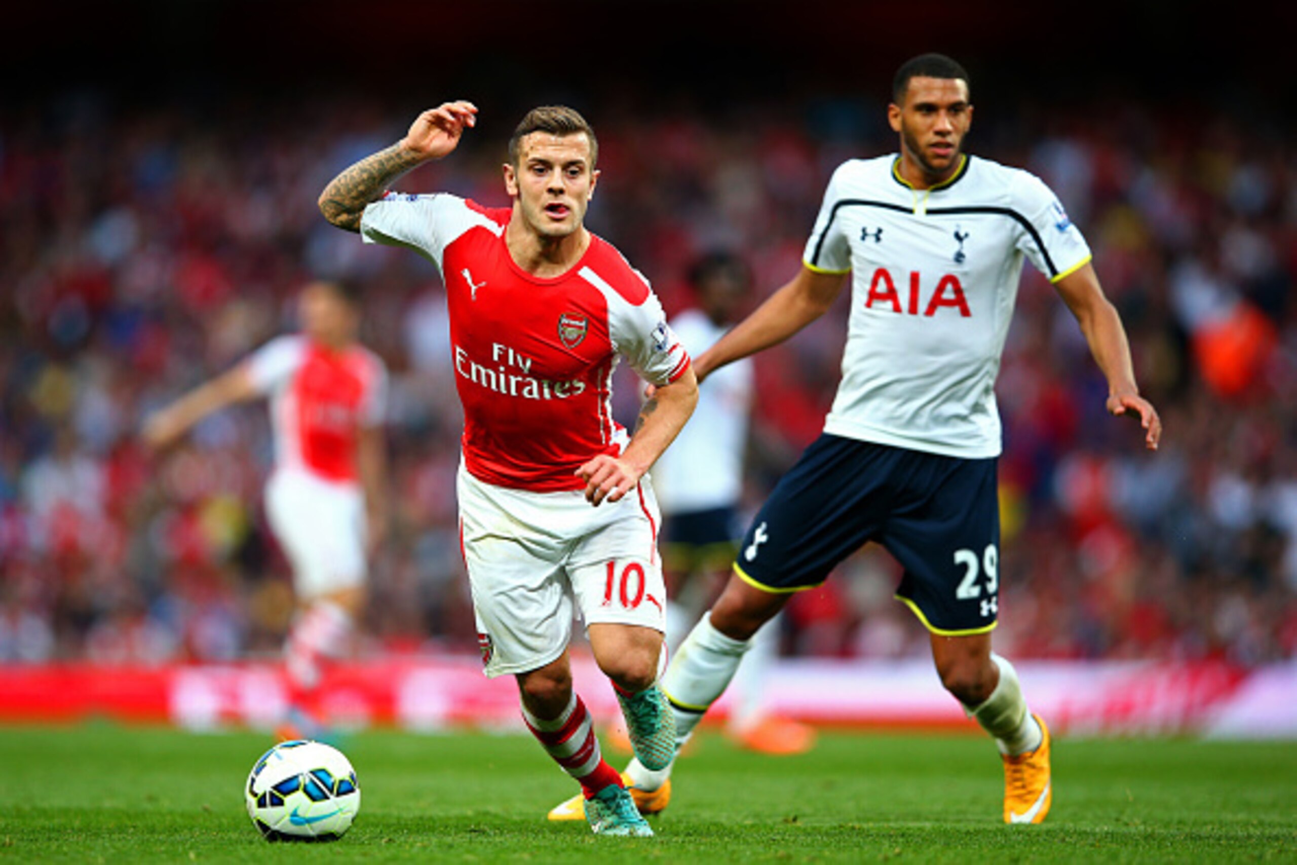 LONDON, ENGLAND - SEPTEMBER 27:  Jack Wilshere of Arsenal runs with the ball past Etienne Capoue of Spurs during the Barclays Premier League match between Arsenal and Tottenham Hotspur at Emirates Stadium on September 27, 2014 in London, England.  (Photo 