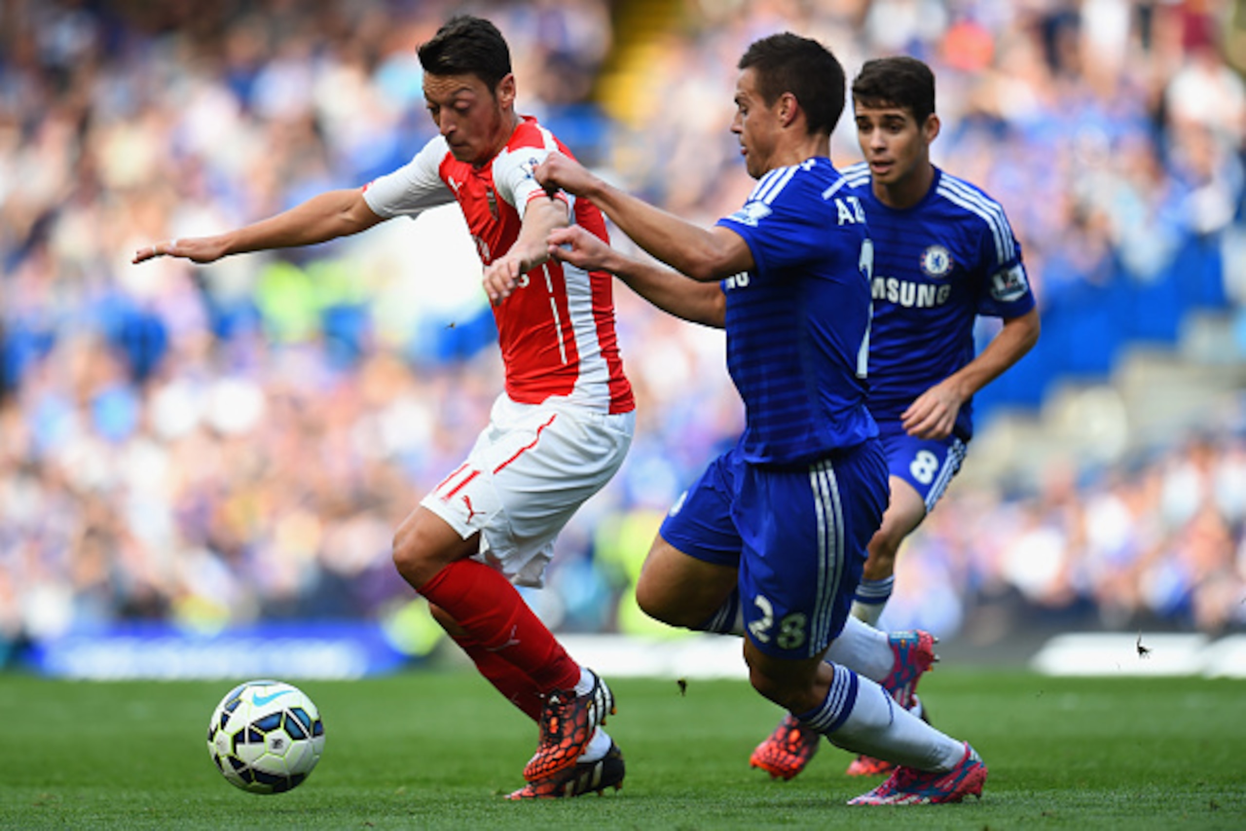 LONDON, ENGLAND - OCTOBER 05:  Mesut Oezil of Arsenal is closed down by Cesar Azpilicueta of Chelsea during the Barclays Premier League match between Chelsea and Arsenal at Stamford Bridge on October 4, 2014 in London, England.  (Photo by Shaun Botterill/