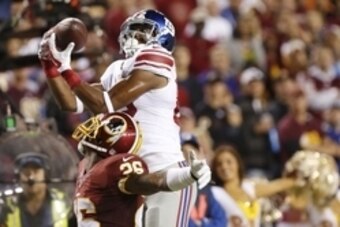 Sep 25, 2014; Landover, MD, USA; New York Giants wide receiver Rueben Randle (82) leaps to catch the ball over Washington Redskins strong safety Bashaud Breeland (26) in the third quarter at FedEx Field. The Giants won 45-14. Mandatory Credit: Geoff Burke