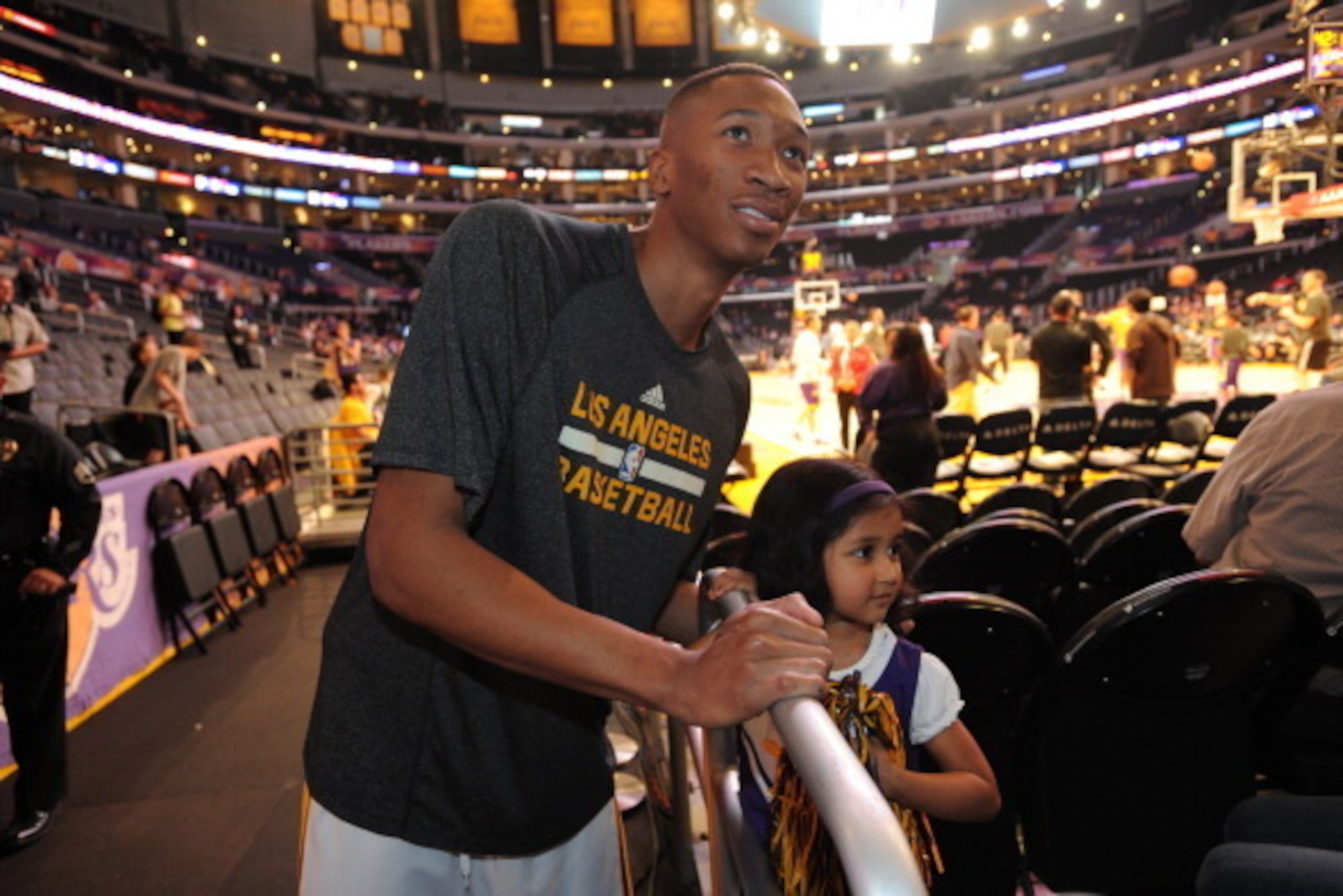 LOS ANGELES, CA - APRIL 13: Wesley Johnson #11 of the Los Angeles Lakers poses for a photograph with a fan before a game against the Memphis Grizzlies at Staples Center on April 13, 2014 in Los Angeles, California. NOTE TO USER: User expressly acknowledge