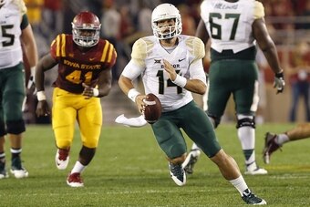 AMES, IA - SEPTEMBER 27: Quarterback Bryce Petty #14 of the Baylor Bears scrambles under pressure from defensive end Darius White #41 of the Iowa State Cyclones in the first half of play at Jack Trice Stadium on September 27, 2014 in Ames, Iowa. Baylor de