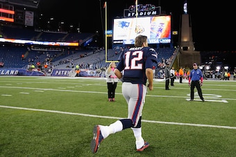 FOXBORO, MA - OCTOBER 05:  Tom Brady #12 of the New England Patriots runs off the field after playing the Cincinnati Bengals at Gillette Stadium on October 5, 2014 in Foxboro, Massachusetts.  (Photo by Jim Rogash/Getty Images)
