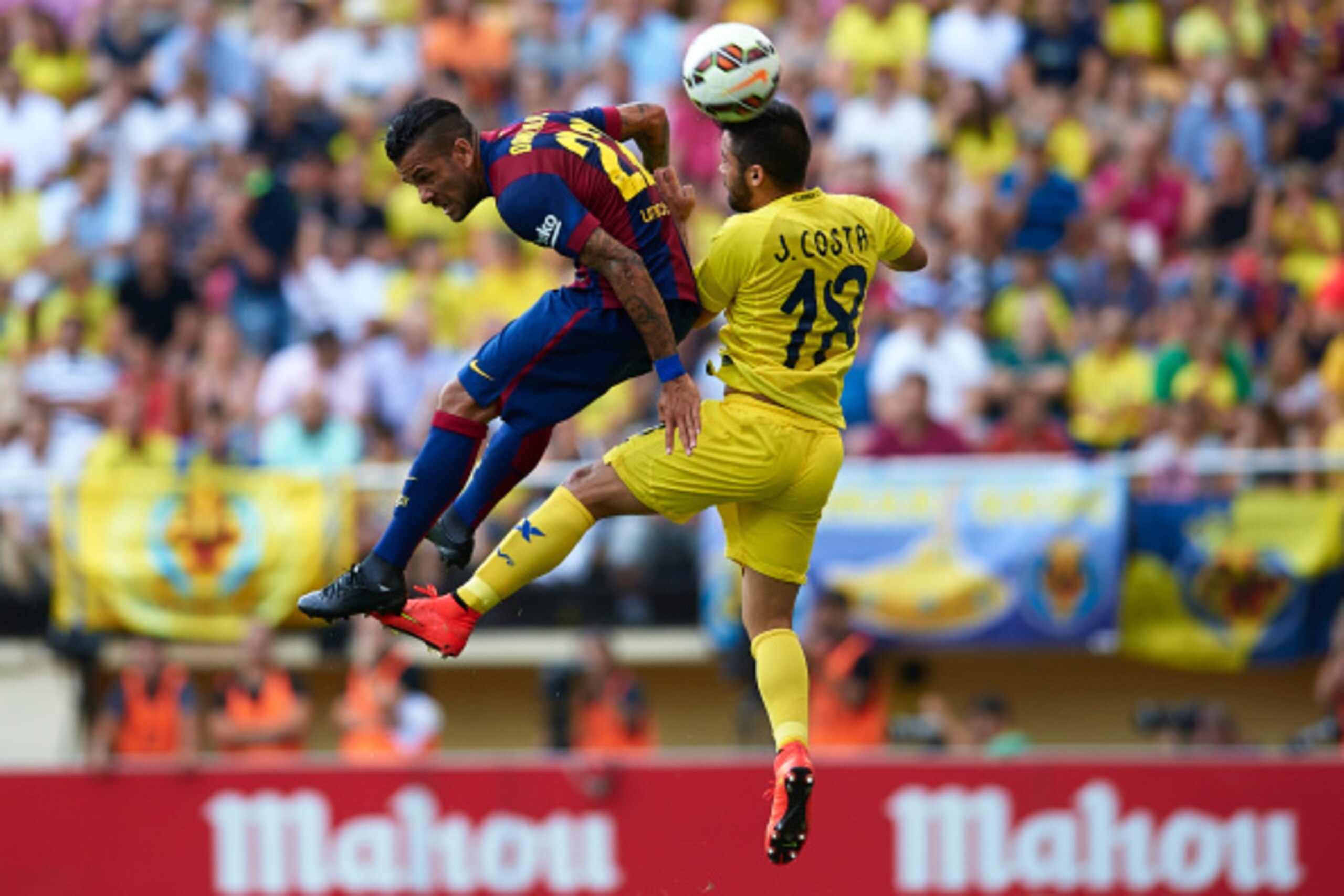 VILLARREAL, SPAIN - AUGUST 31:  Dani Alves (L) of Barcelona competes for a high ball with Jaume Costa of Villarreal during the La Liga match between Villarreal CF and FC Barcelona at El Madrigal stadium on August 31, 2014 in Villarreal, Spain.  (Photo by 