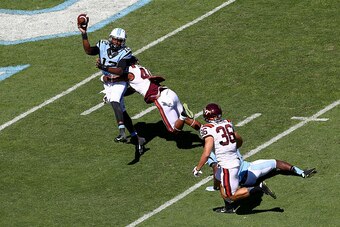 CHAPEL HILL, NC - OCTOBER 04:  Deon Clarke #40 of the Virginia Tech Hokies hits Marquise Williams #12 of the North Carolina Tar Heels during their game at Kenan Stadium on October 4, 2014 in Chapel Hill, North Carolina.  (Photo by Streeter Lecka/Getty Ima