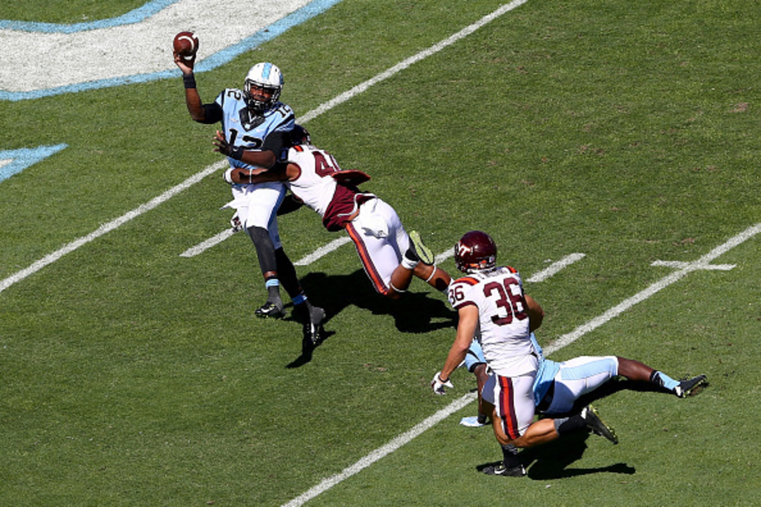 CHAPEL HILL, NC - OCTOBER 04:  Deon Clarke #40 of the Virginia Tech Hokies hits Marquise Williams #12 of the North Carolina Tar Heels during their game at Kenan Stadium on October 4, 2014 in Chapel Hill, North Carolina.  (Photo by Streeter Lecka/Getty Ima
