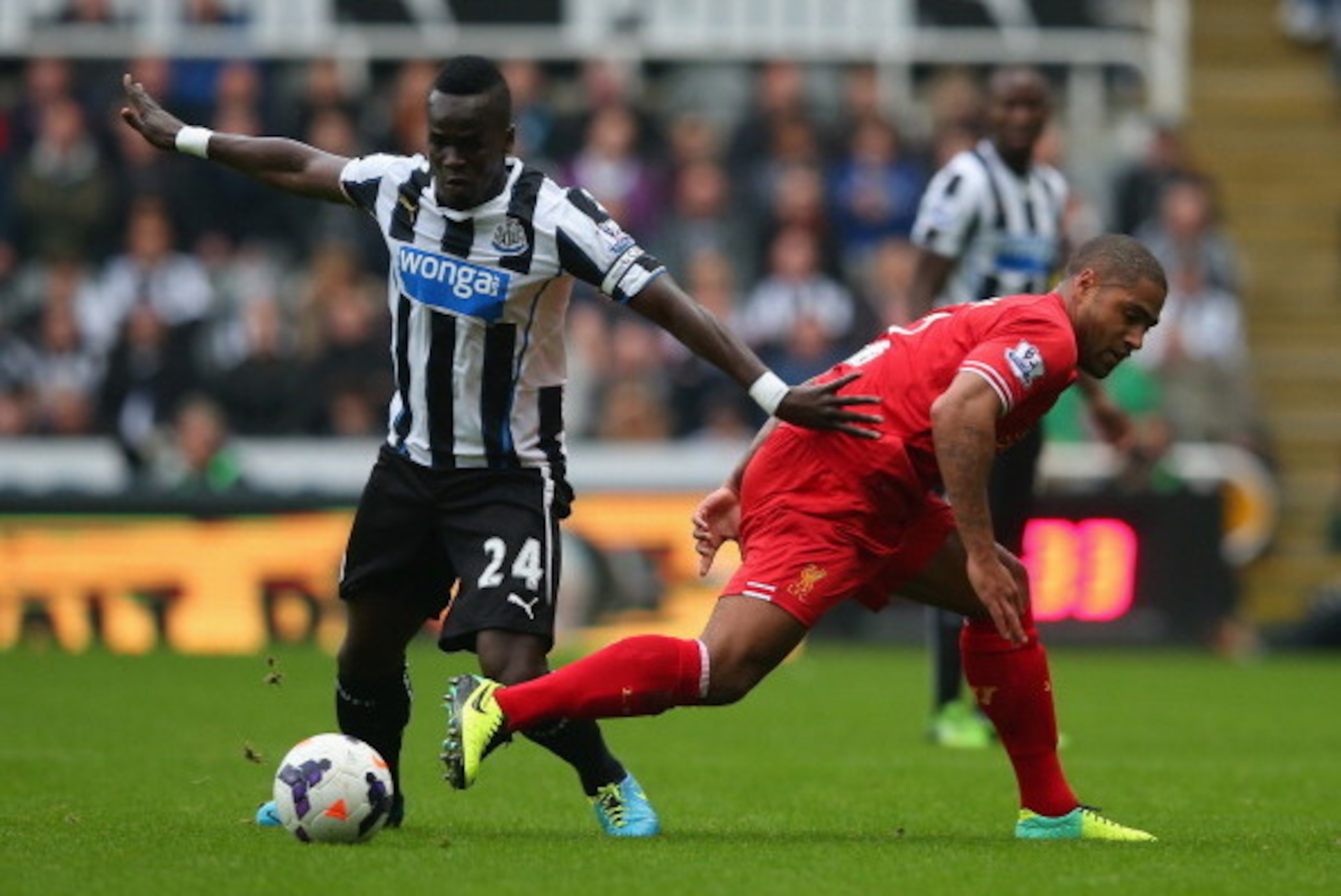 NEWCASTLE UPON TYNE, ENGLAND - OCTOBER 19:  Cheik Ismael Tiote of Newcastle United and Glen Johnson of Liverpool battle for the ball during the Barclays Premier League match between Newcastle United and Liverpool at St James' Park on October 19, 2013 in N