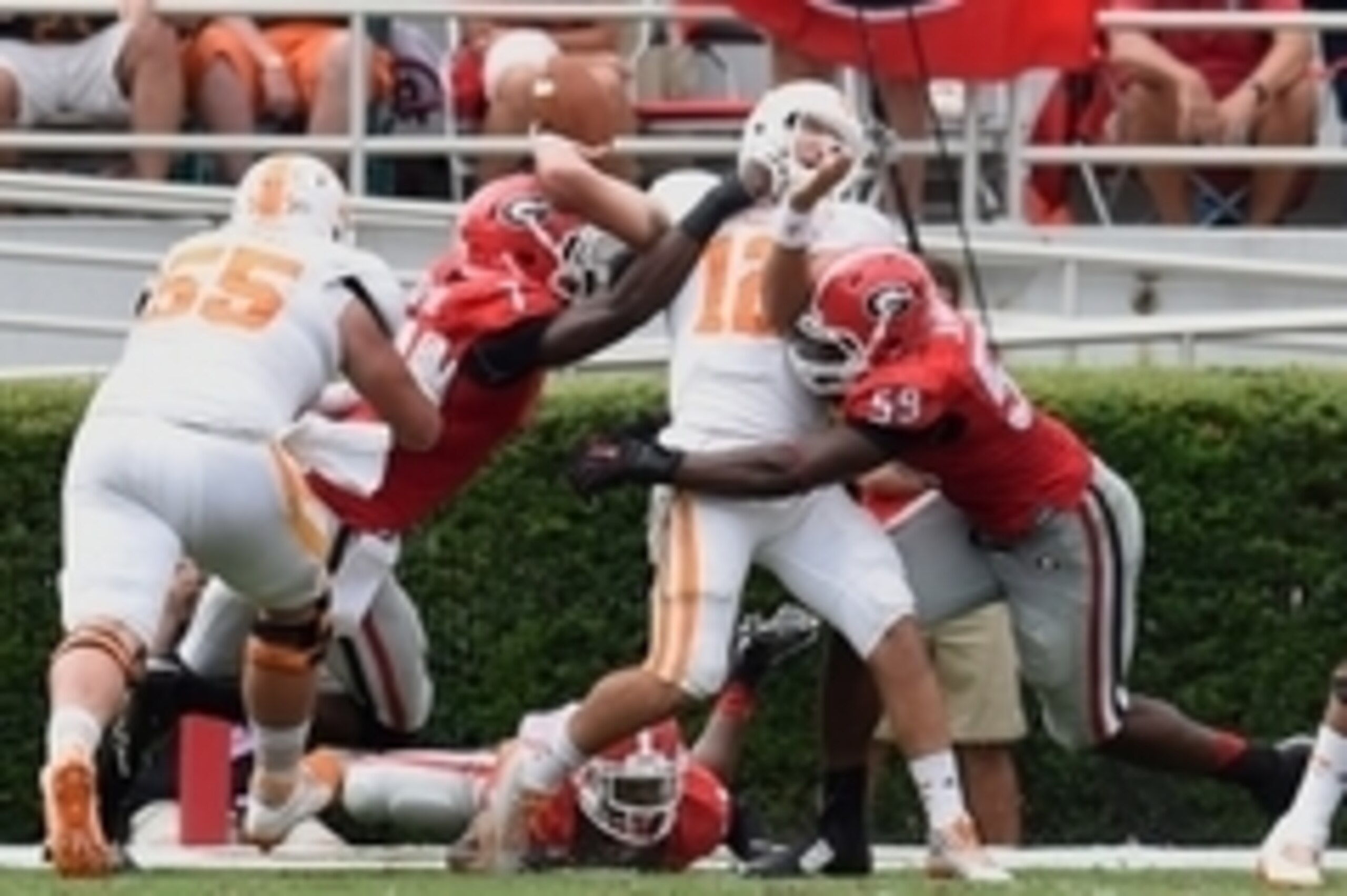 Sep 27, 2014; Athens, GA, USA; Tennessee Volunteers quarterback Nathan Peterman (12) is hit by Georgia Bulldogs linebacker Lorenzo Carter (7) and linebacker Jordan Jenkins (59) during the second half at Sanford Stadium. Georgia defeated Tennessee 35-32. M