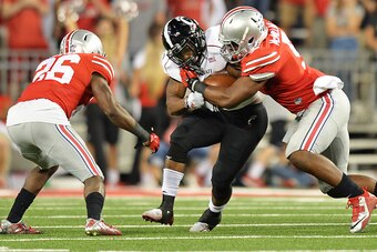 COLUMBUS, OH - SEPTEMBER 27:  Hosey Williams #23 of the Cincinnati Bearcats is wrapped up after a short gain by Armani Reeves #26 and Raekwon McMillan #5 of the Ohio State Buckeyes in the third quarter at Ohio Stadium on September 27, 2014 in Columbus, Oh