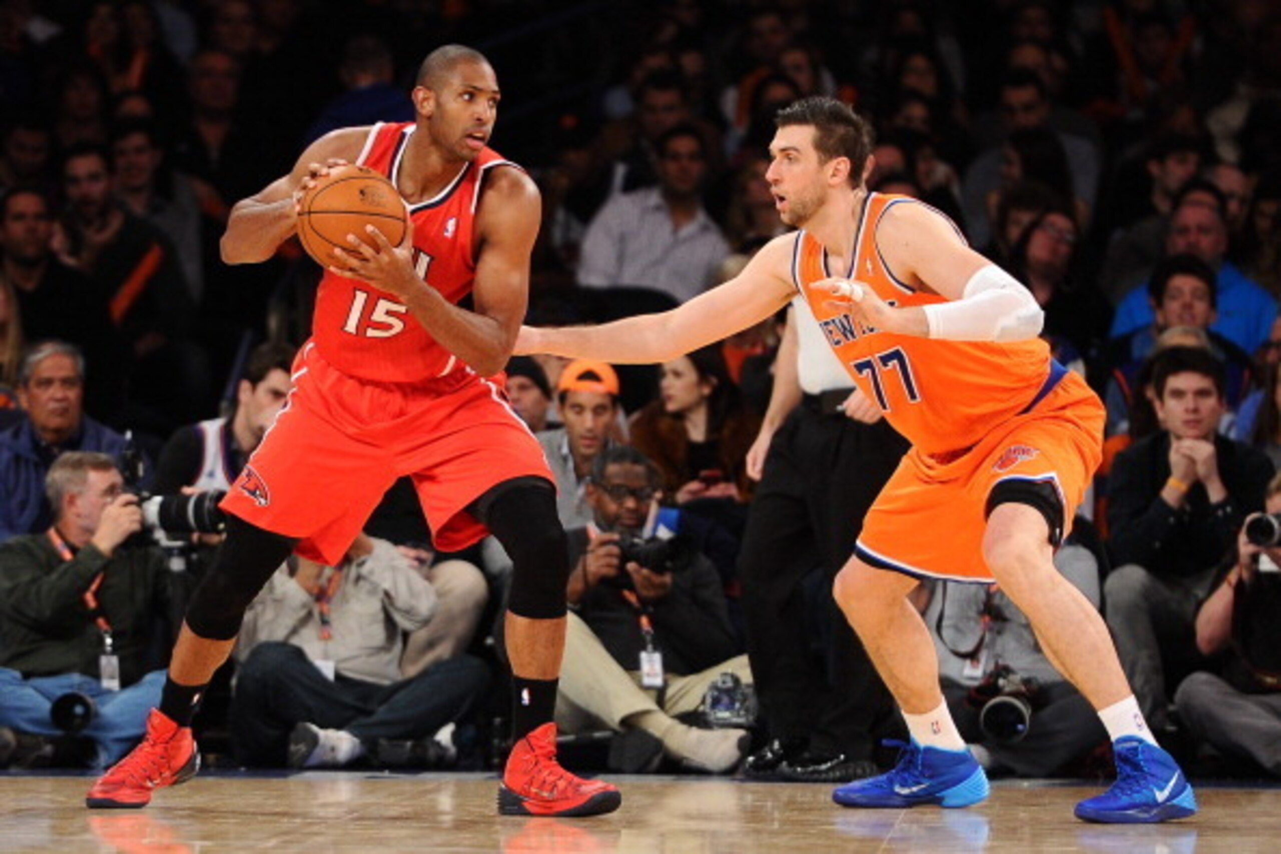 NEW YORK, NY - NOVEMBER 16:  Al Horford #15 of the Atlanta Hawks looks for a pass with pressure from Andrea Bargnani #77 of the New York Knicks at Madison Square Garden on November 16, 2013 in New York City. The Hawks defeat the Knicks 110-90. NOTE TO USE