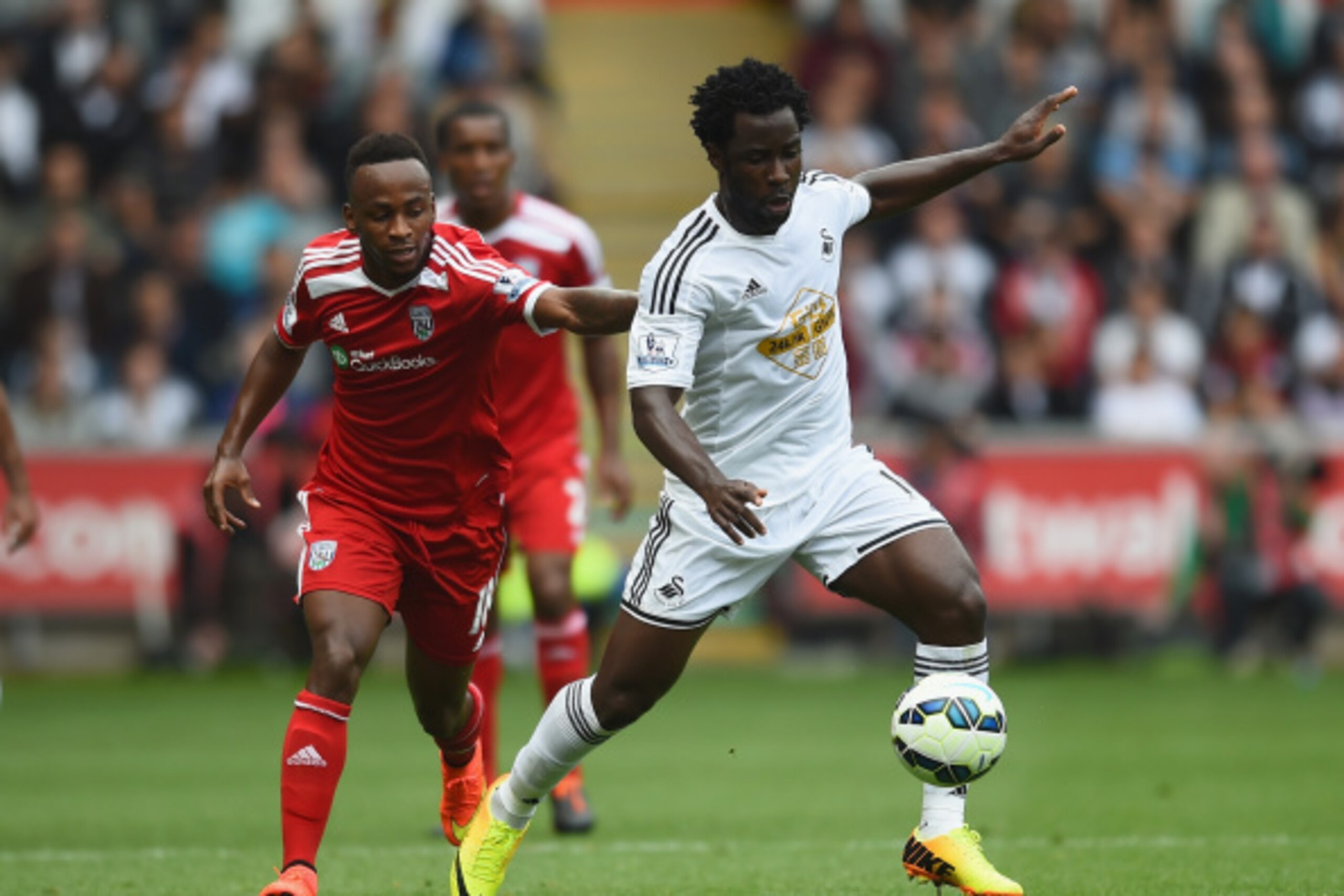 SWANSEA, WALES - AUGUST 30:  Wilfried Bony of Swansea gets away from Saido Berahino of West Brom during the Barclays Premier League match between Swansea City and West Bromwich Albion at Liberty Stadium on August 30, 2014 in Swansea, Wales.  (Photo by Chr