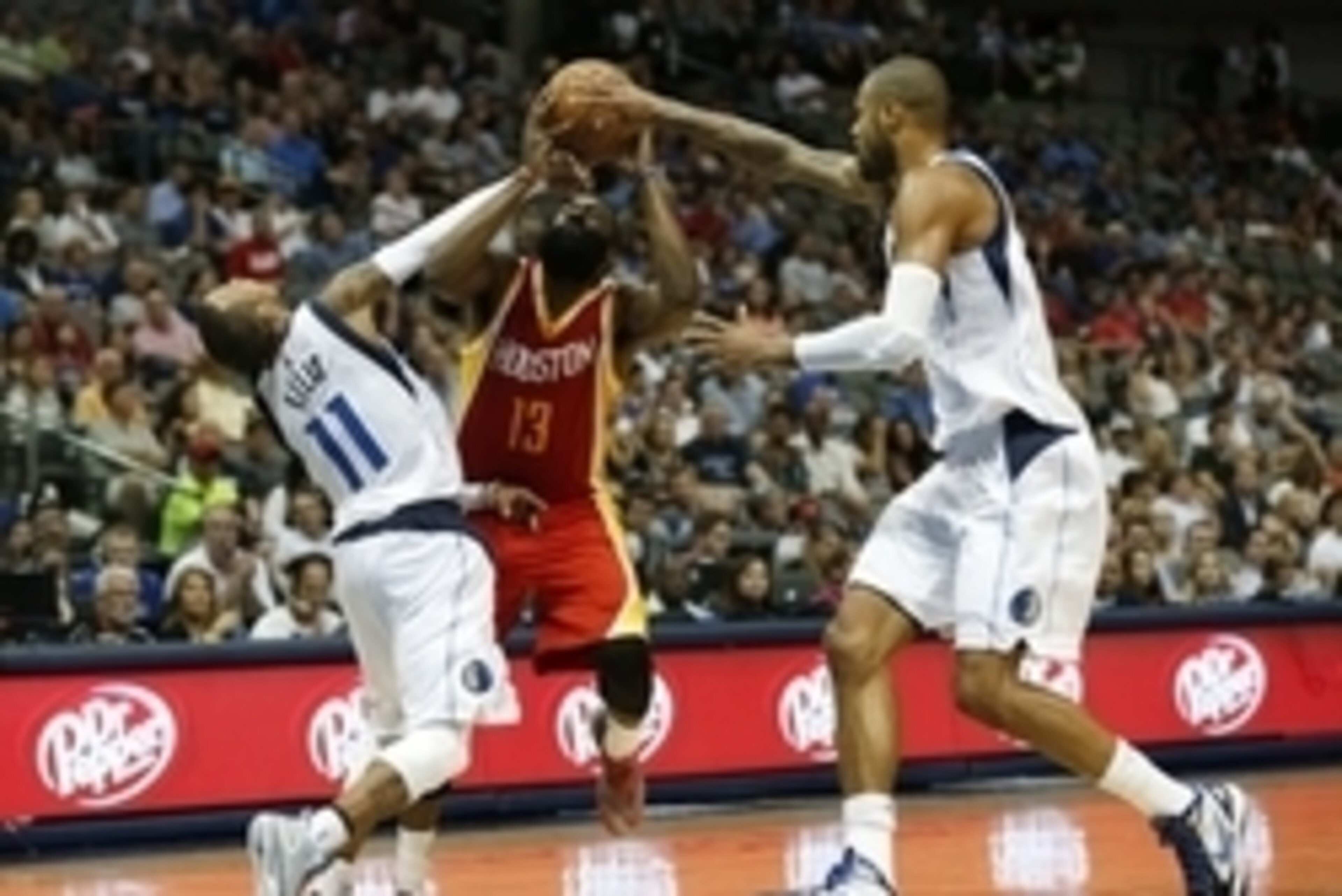 Oct 7, 2014; Dallas, TX, USA; Houston Rockets guard James Harden (13) is fouled by Dallas Mavericks guard Monta Ellis (11) as center Tyson Chandler (6) defends at American Airlines Center. Mandatory Credit: Matthew Emmons-USA TODAY Sports