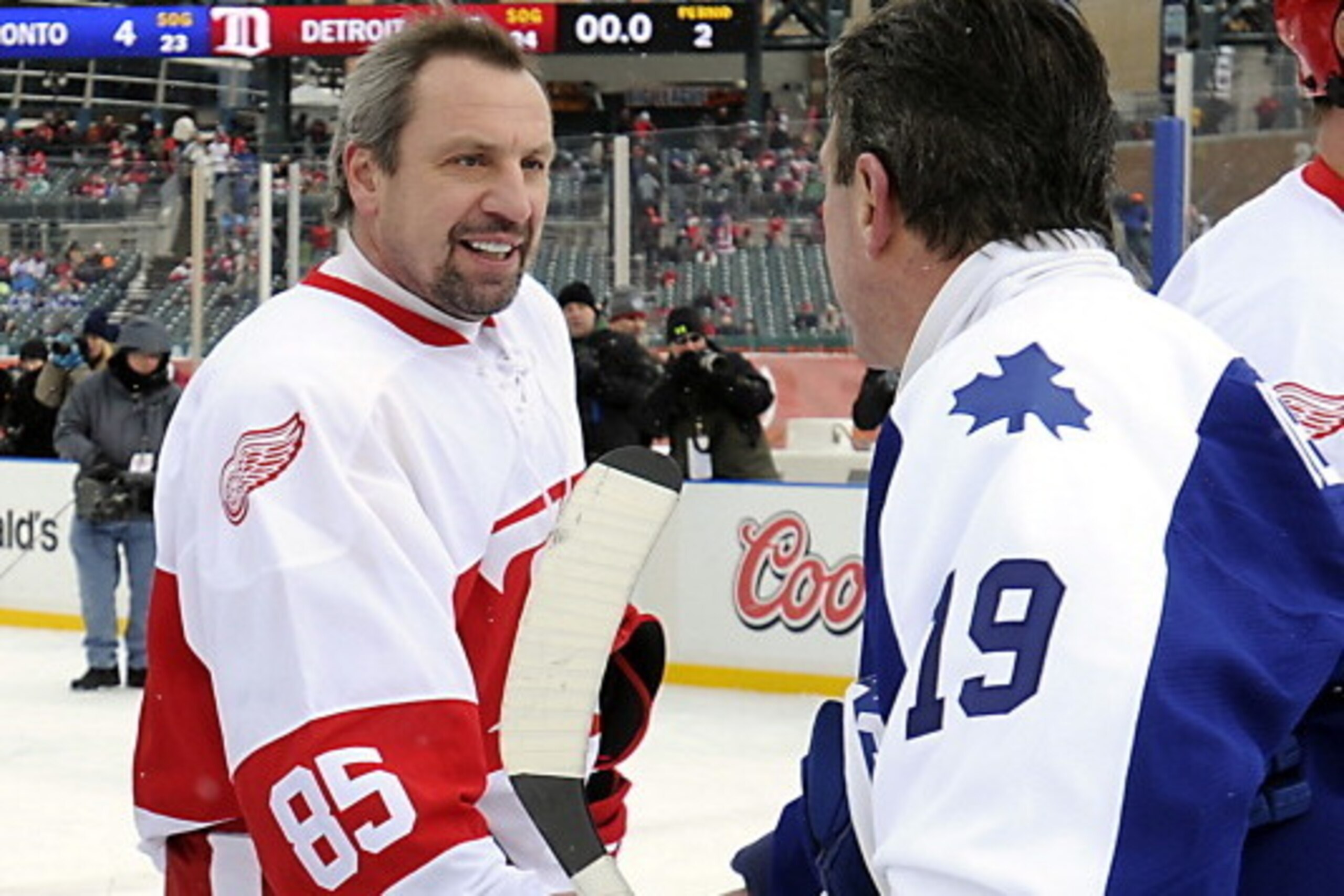 DETROIT, MI - DECEMBER 31: Bill Derlago #19 of the Toronto Maple Leafs Alumni and Petr Klima #85 of the Detroit Red Wings Alumni shake hands after the game on December 31, 2013 at Comerica Park in Detroit, Michigan. (Photo by Graig Abel/NHLI  via Getty Im