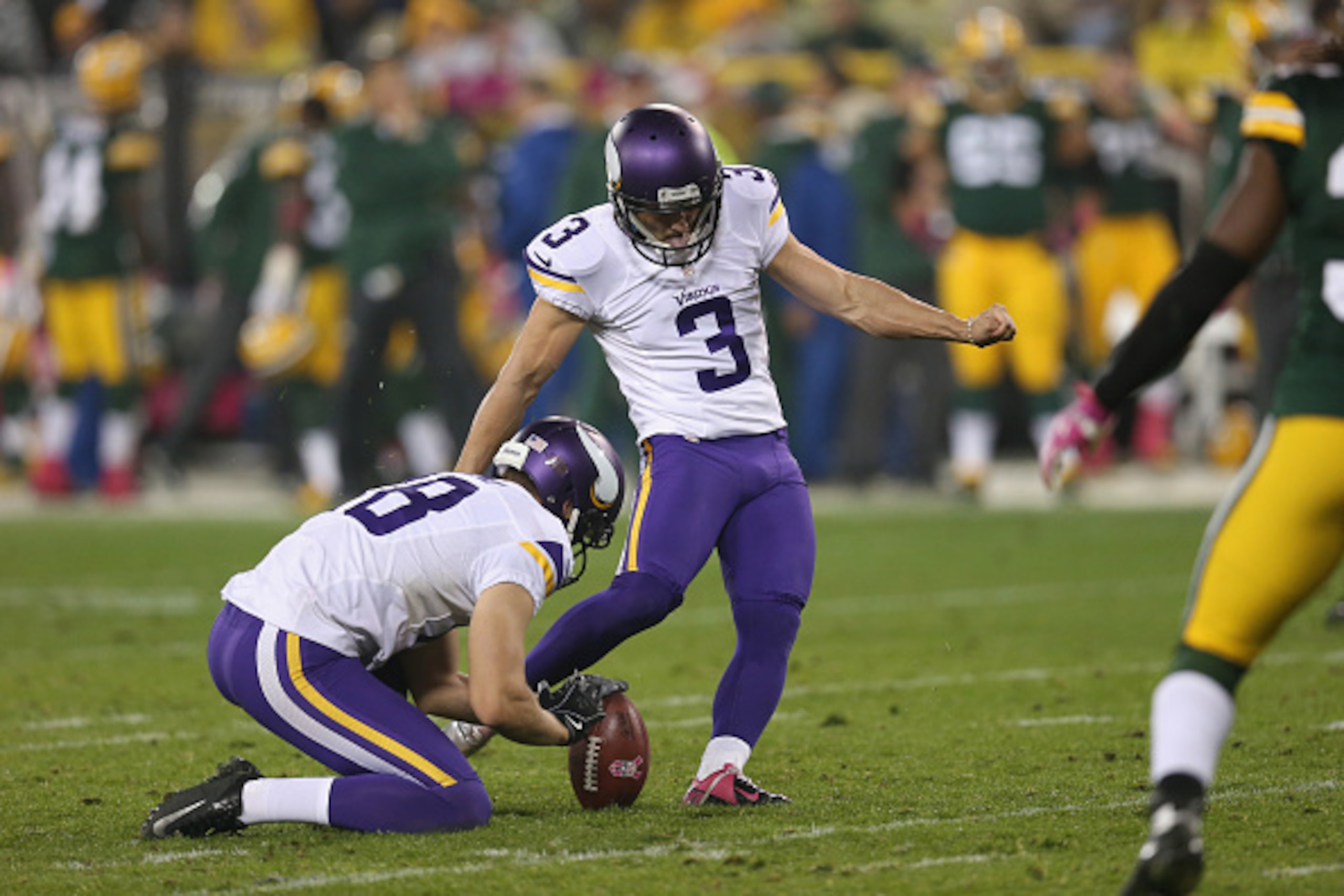 GREEN BAY, WI - OCTOBER 02:  Blair Walsh #3 of the Minnesota Vikings kicks a field goal out of the hold of  Jeff Locke #18 in the forth quarter of the NFL game against the Green Bay Packers at Lambeau Field on October 2, 2014 in Green Bay, Wisconsin.  Pac