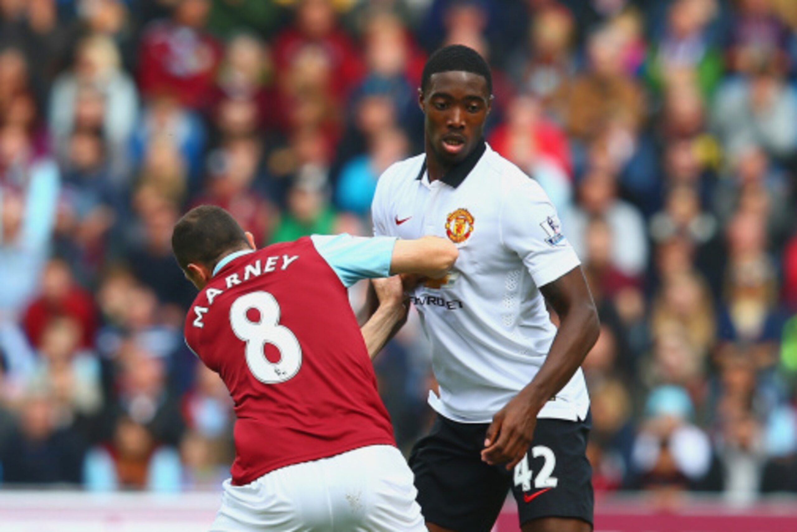 BURNLEY, ENGLAND - AUGUST 30:  Dean Marney of Burnley and Tyler Blackett of Manchester United battle for the ball during the Barclays Premier League match between Burnley and Manchester United at Turf Moor on August 30, 2014 in Burnley, England.  (Photo b