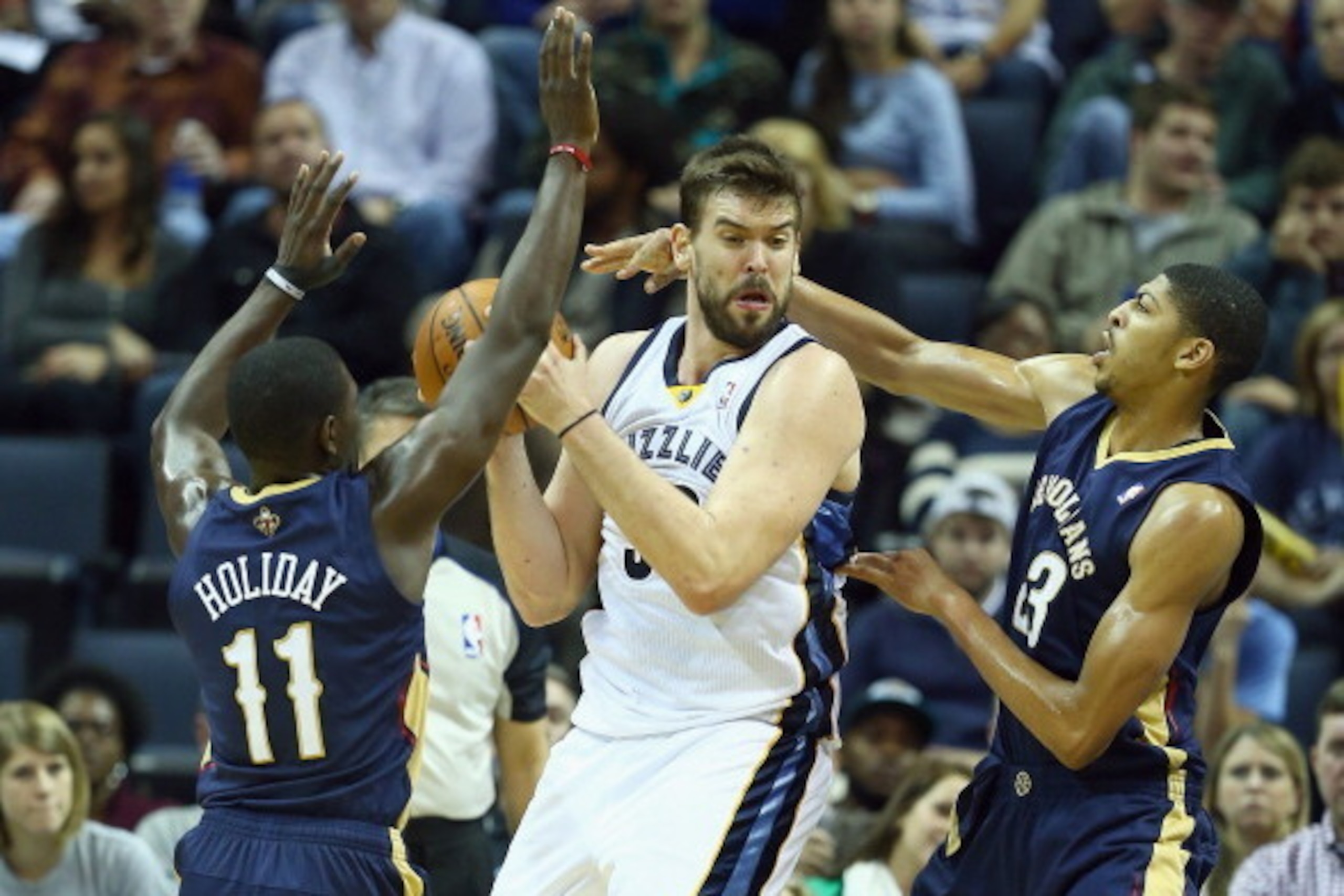 MEMPHIS, TN - NOVEMBER 06:  Marc Gasol #33 of the Memphis Grizzlies looks to pass the ball while defended by Jrue Holiday #11 and Anthony Davis #23 of the New Orleans Pelicans during the NBA game at FedExForum on November 6, 2013 in Memphis, Tennessee.  N