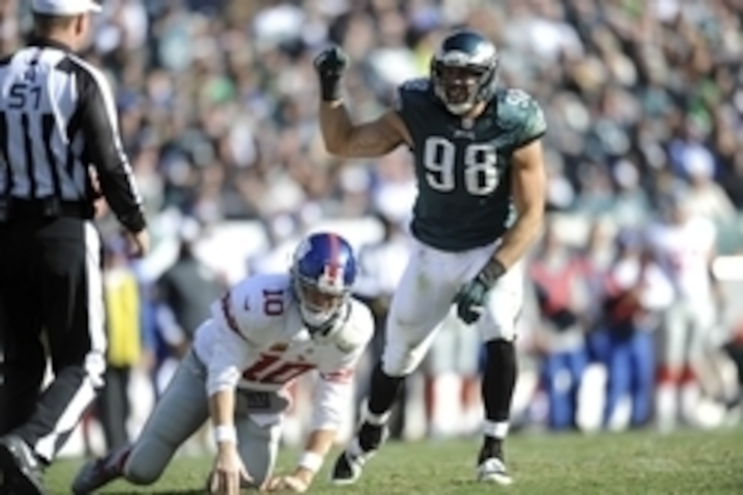Oct 27, 2013; Philadelphia, PA, USA; New York Giants quarterback Eli Manning (10) is knocked down by Philadelphia Eagles outside linebacker Connor Barwin (98) after throwing a pass during the second half at Lincoln Financial Field. The Giants won the game