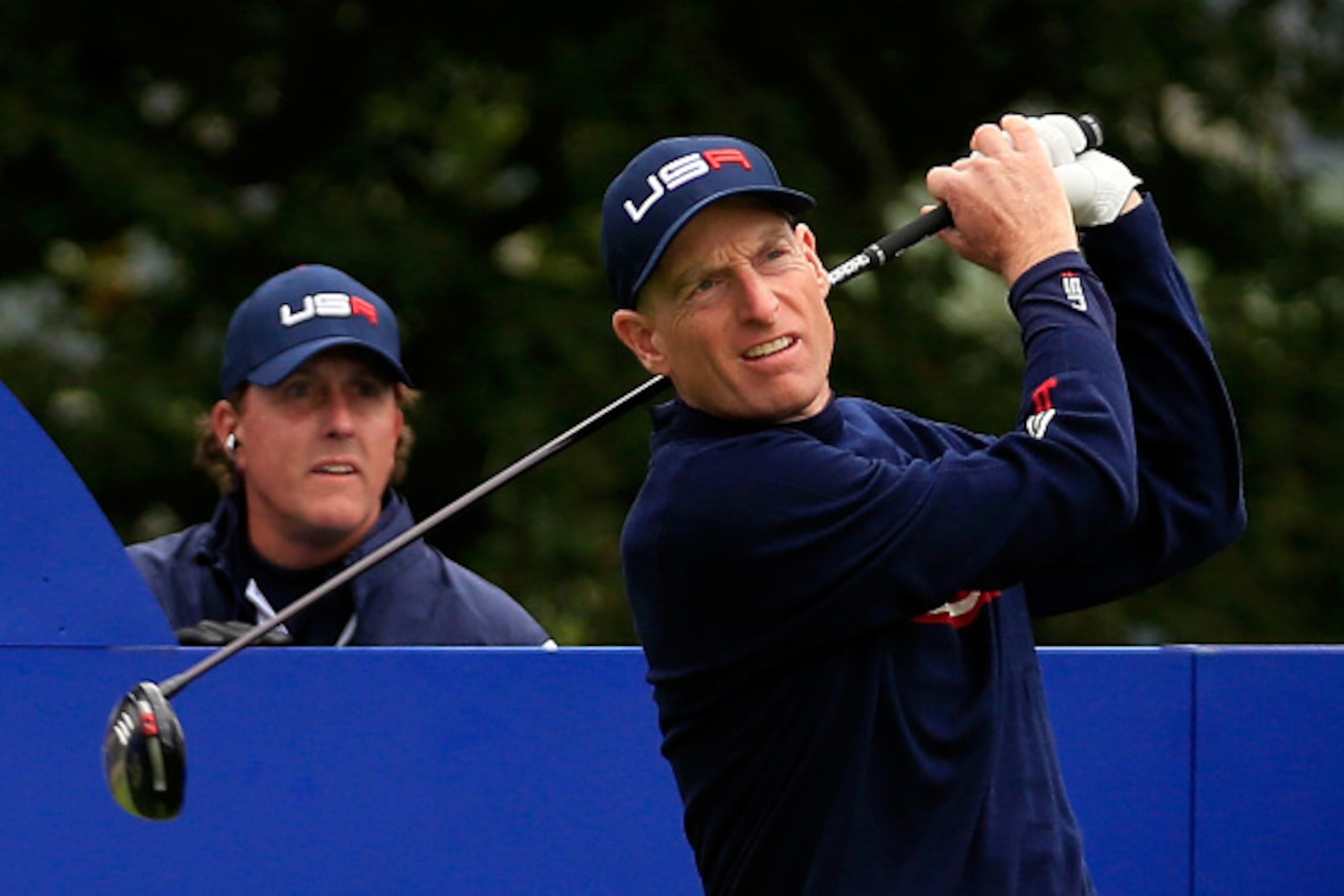 AUCHTERARDER, SCOTLAND - SEPTEMBER 27: Jim Furyk of the United States tees off on the 5th hole watched by Phil Mickelson of the United States during the Afternoon Foursomes of the 2014 Ryder Cup on the PGA Centenary course at the Gleneagles Hotel on Septe