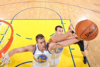 OAKLAND, CA - DECEMBER 19: David Lee #10 and Andrew Bogut #12 of the Golden State Warriors combine for the rebound against the San Antonio Spurs on December 19, 2013 at Oracle Arena in Oakland, California. NOTE TO USER: User expressly acknowledges and agr