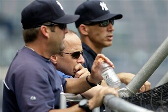 Within hours of extending Brian Cashman (middle), the Yankees shook up manager Joe Girardi's (right) staff by letting go of hitting coach Kevin Long (foreground).