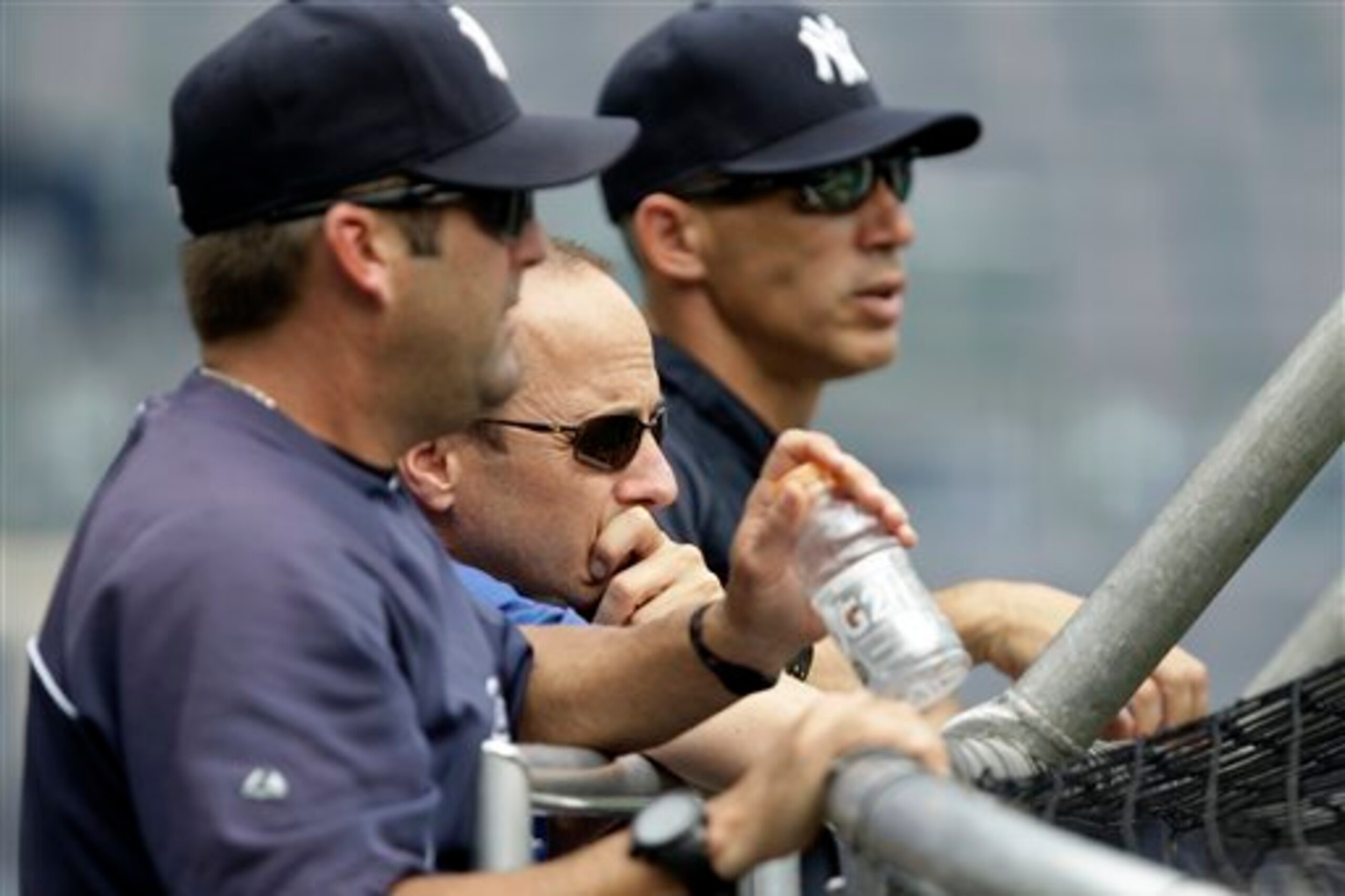 Within hours of extending Brian Cashman (middle), the Yankees shook up manager Joe Girardi's (right) staff by letting go of hitting coach Kevin Long (foreground).