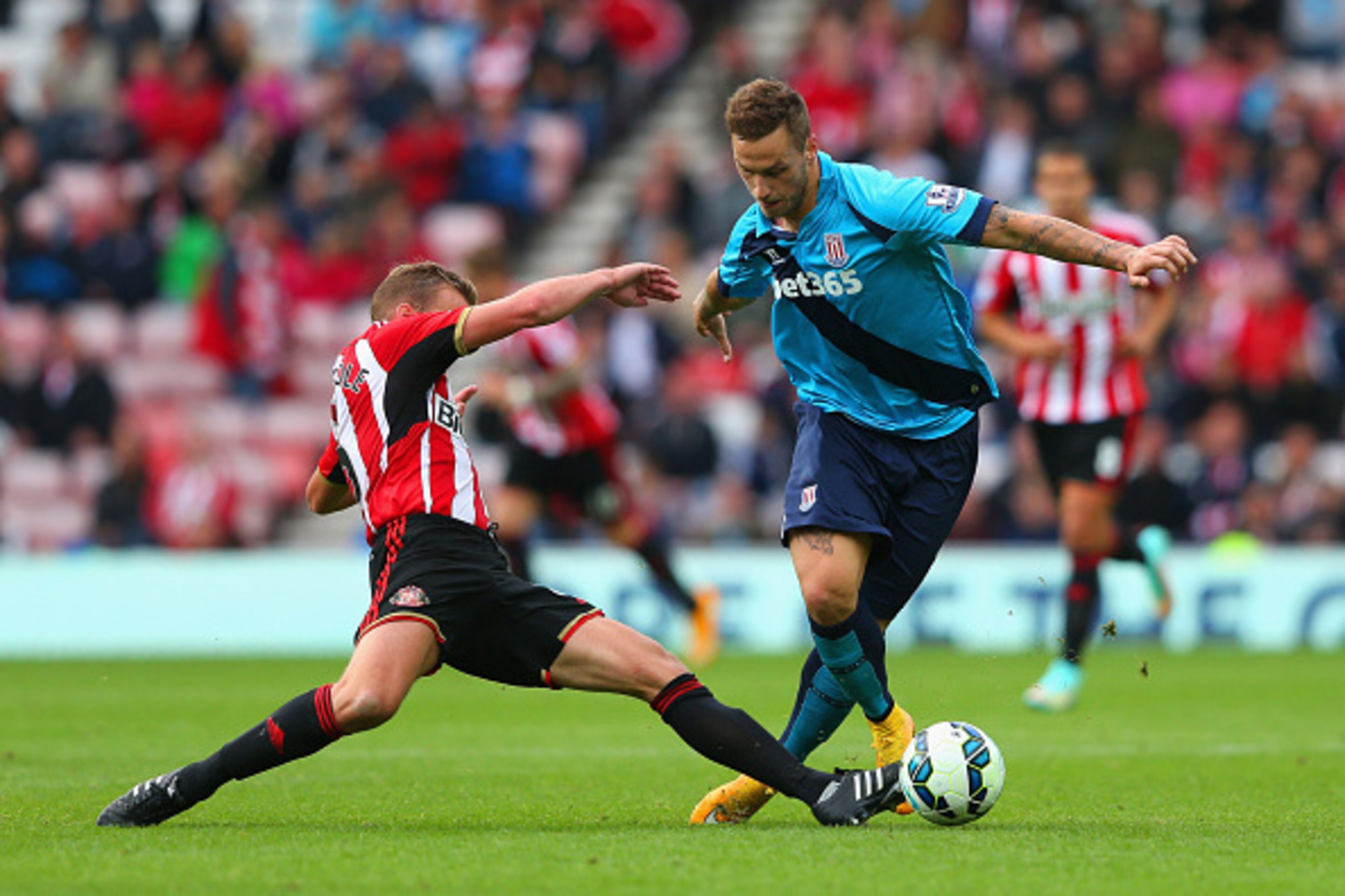 SUNDERLAND, ENGLAND - OCTOBER 04: Lee Cattermole of Sunderland tackles Marko Arnautovic of Stoke City  during the Barclays Premier League match between Sunderland and Stoke City at Stadium of Light on October 4, 2014 in Sunderland, England.  (Photo by Ale