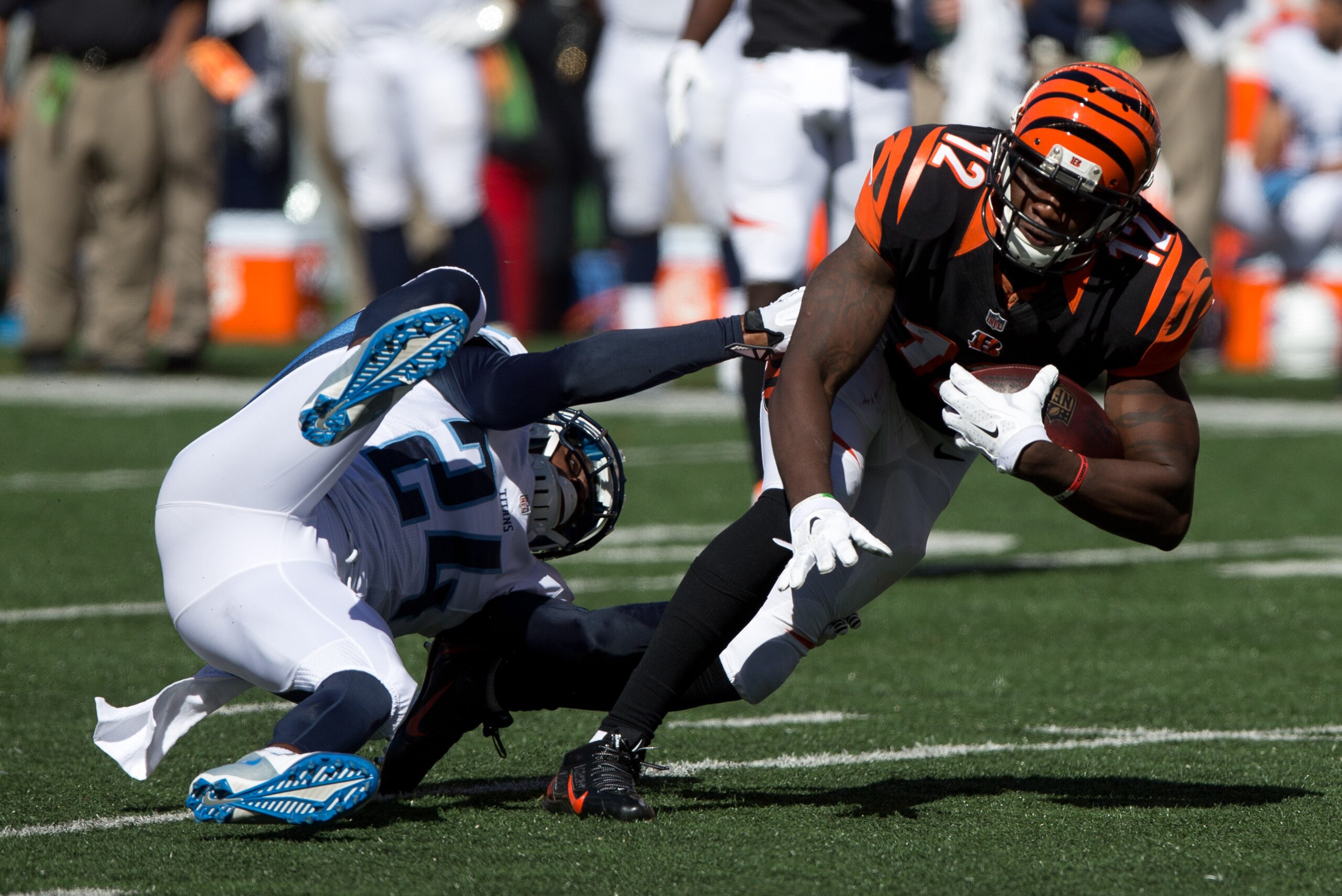 Sep 21, 2014; Cincinnati, OH, USA; Cincinnati Bengals wide receiver Mohamed Sanu (12) is tackled by Tennessee Titans cornerback Coty Sensabaugh (24) at Paul Brown Stadium. The Bengals won 33-7. Mandatory Credit: Aaron Doster-USA TODAY Sports