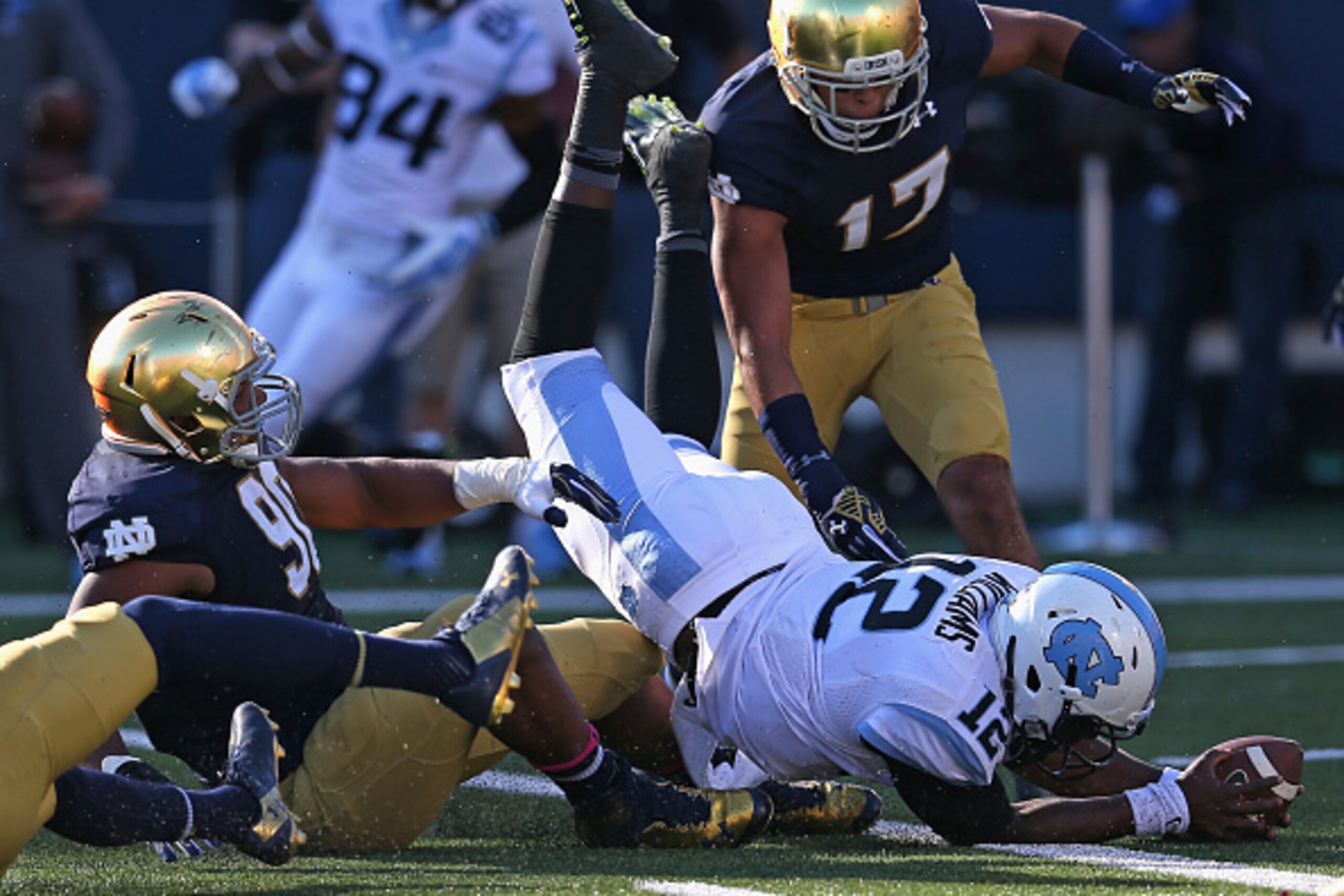SOUTH BEND, IN - OCTOBER 11: Marquise Williams #12 of the North Carolina Tar Heels falls into the end zone to score over Isaac Rochell #90 of the Notre Dame Fighting Irish at Notre Dame Stadium on October 11, 2014 in South Bend, Indiana. (Photo by Jonatha