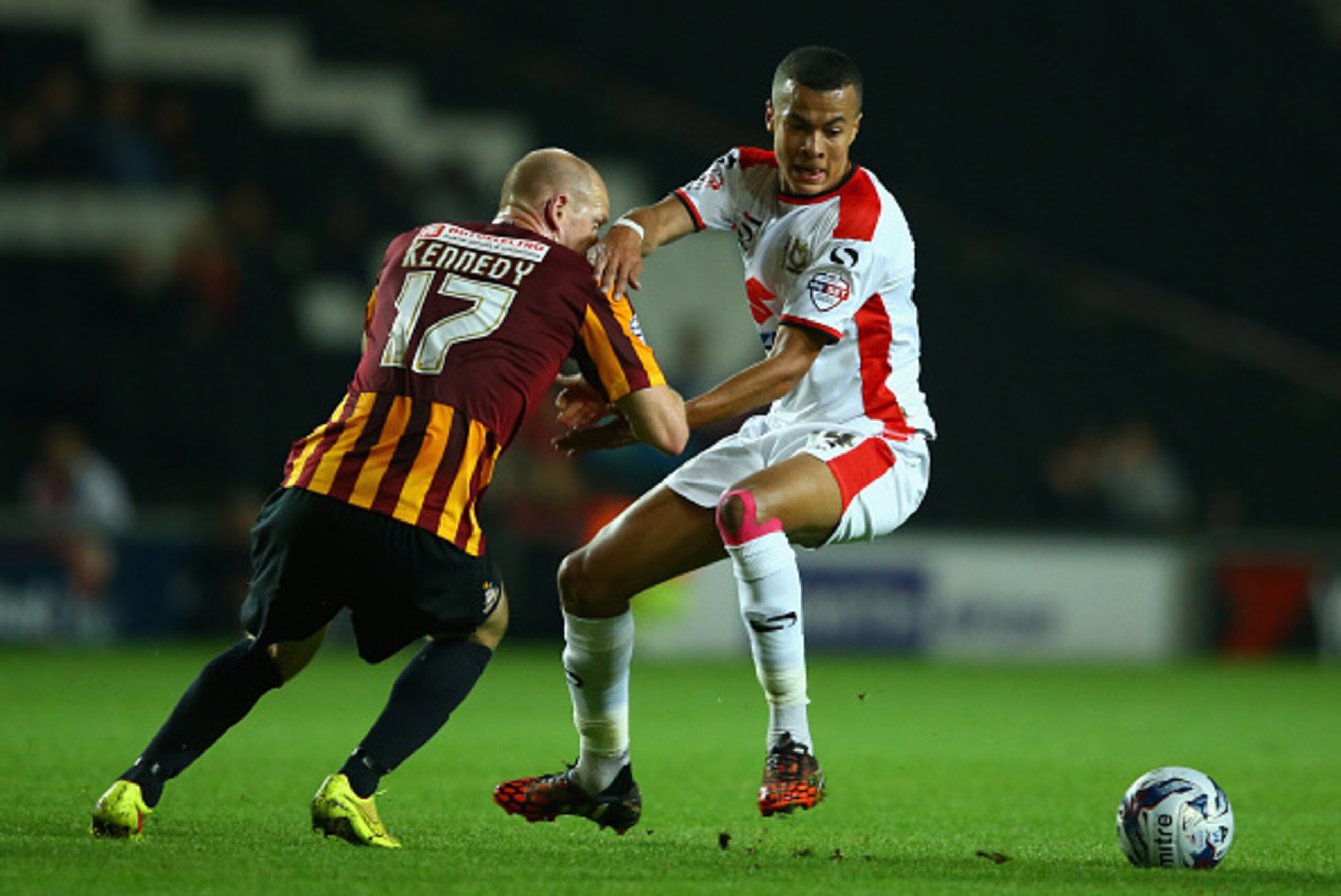 MILTON KEYNES, ENGLAND - SEPTEMBER 23:  Dele Alli of MK Dons holds off Jason Kennedy of Bradford during the Capital One Cup Third Round match between MK Dons and Bradford City at Stadium mk on September 23, 2014 in Milton Keynes, England.  (Photo by Richa