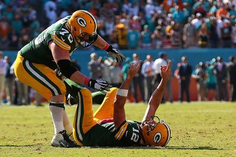 MIAMI GARDENS, FL - OCTOBER 12:  Aaron Rodgers #12 and T.J. Lang #70 of the Green Bay Packers celebrates the winning touchdown during a game against the Miami Dolphins at Sun Life Stadium on October 12, 2014 in Miami Gardens, Florida.  (Photo by Mike Ehrm