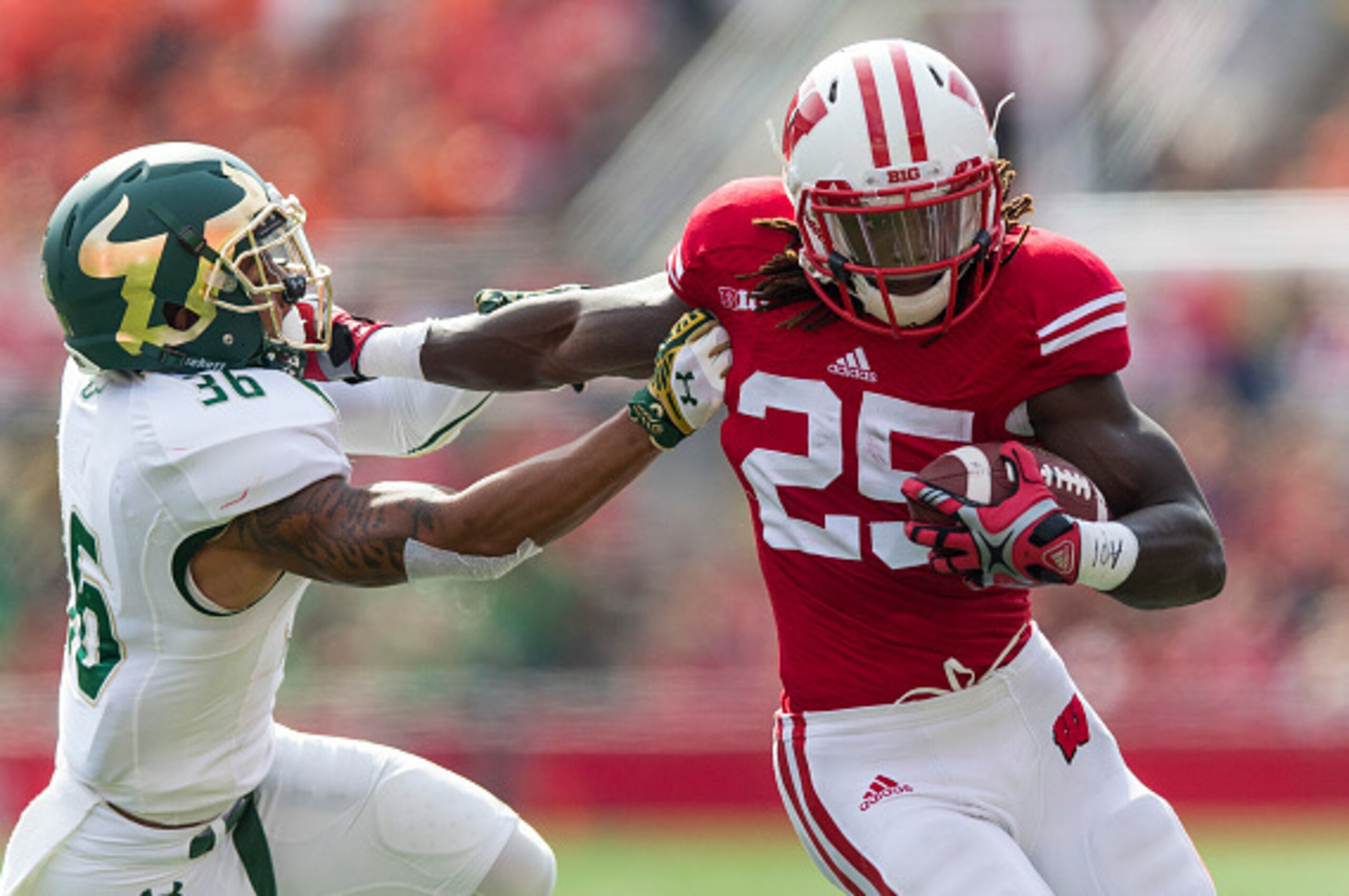 MADISON, WI - SEPTEMBER 27:  Running back Melvin Gordon #25 of the Wisconsin Badgers stiff arms Nate Godwin #36 of the South Florida Bulls on September 27, 2014 at Camp Randall Stadium in Madison, Wisconsin.  (Photo by Tom Lynn/Getty Images)