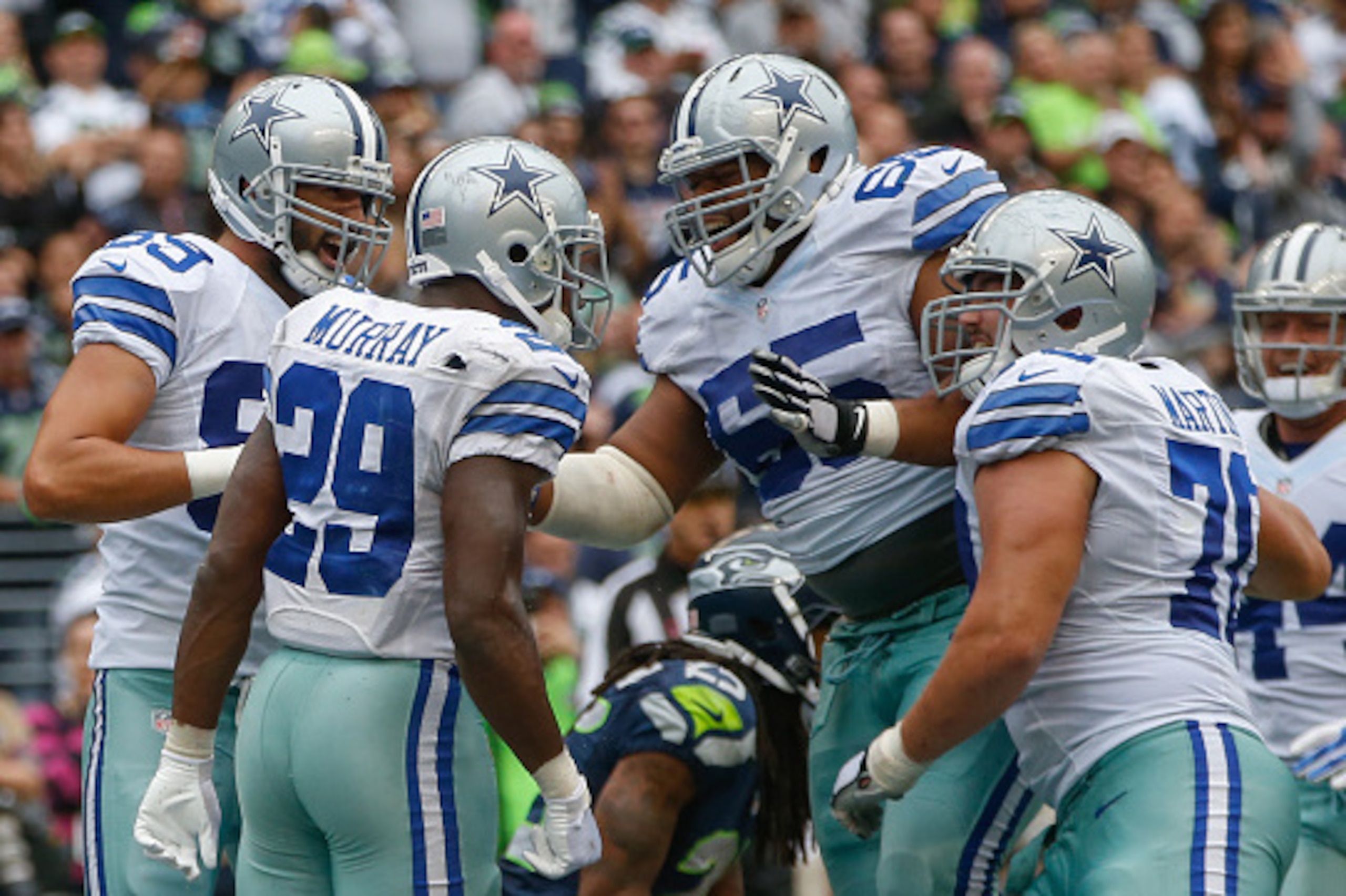 SEATTLE, WA - OCTOBER 12:  Running back DeMarco Murray #29 of the Dallas Cowboys celebrates with teammates after rushing for the winning touchdown in a 30-23 win over the Seattle Seahawks at CenturyLink Field on October 12, 2014 in Seattle, Washington.  (